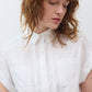 White poplin button-down blouse with pointed collar, front buttons, and chest pocket