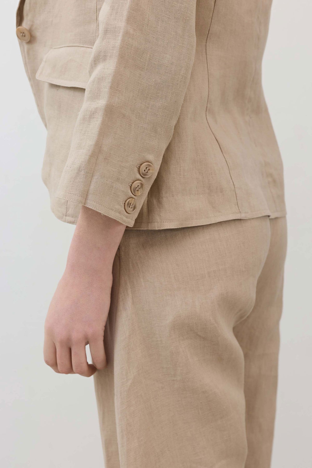 Light beige blazer sleeve detail with buttoned cuff and stitched flap pocket