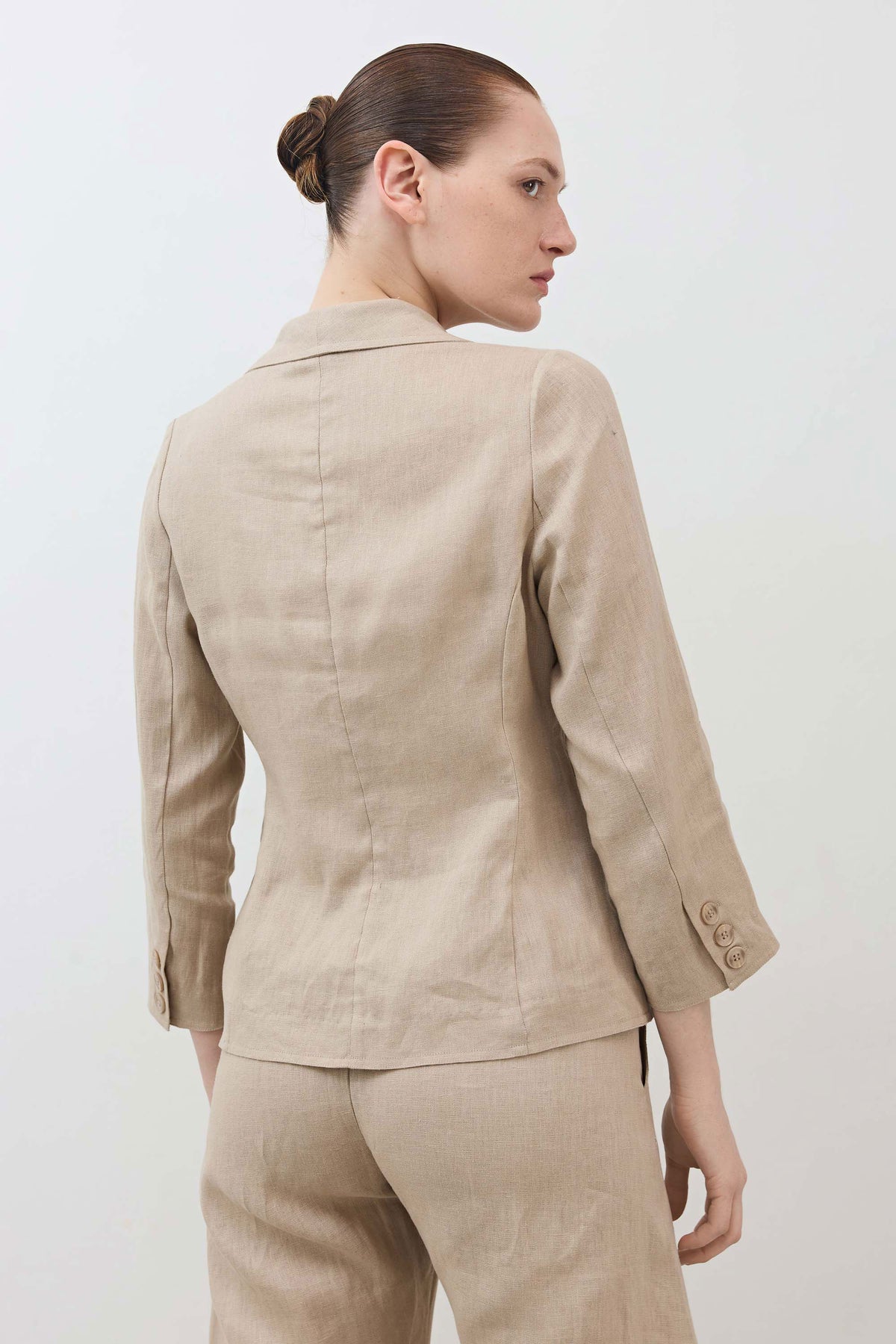 Back view cropped tulip-hem blazer in light beige, single button closure at hem