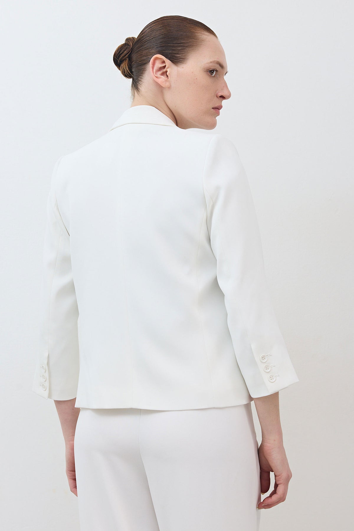 White shrunken blazer with 3/4 sleeves, cropped back view, tailored seams.