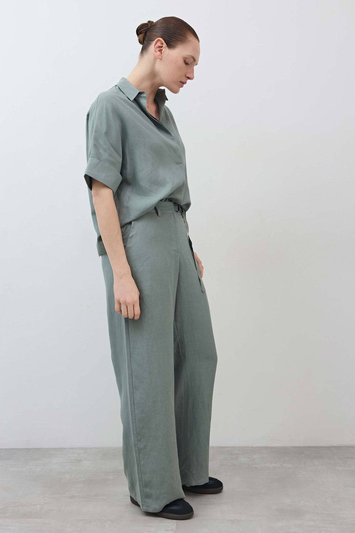 Chinois green wide-leg trousers with belted waist and long drape, side seam detail