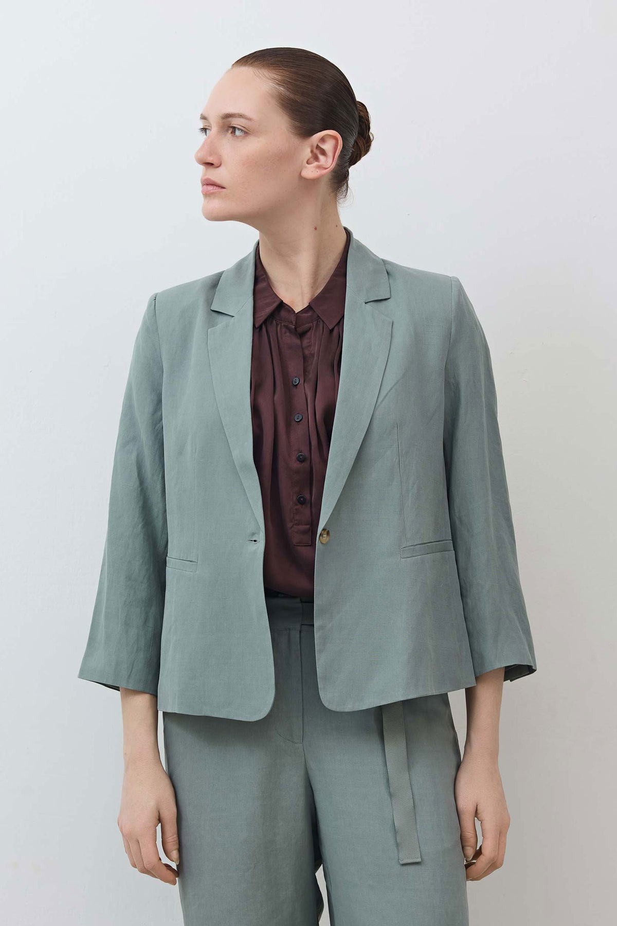 Chinois green shrunken blazer with notch lapels, button front, over dark red shirt