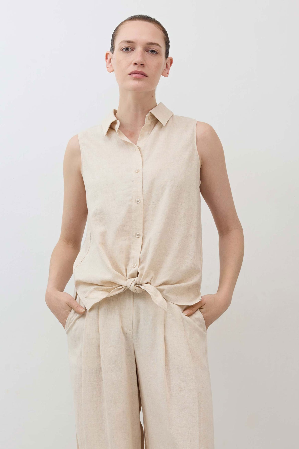 Oatmeal sleeveless button-down top with collar and front tie knot