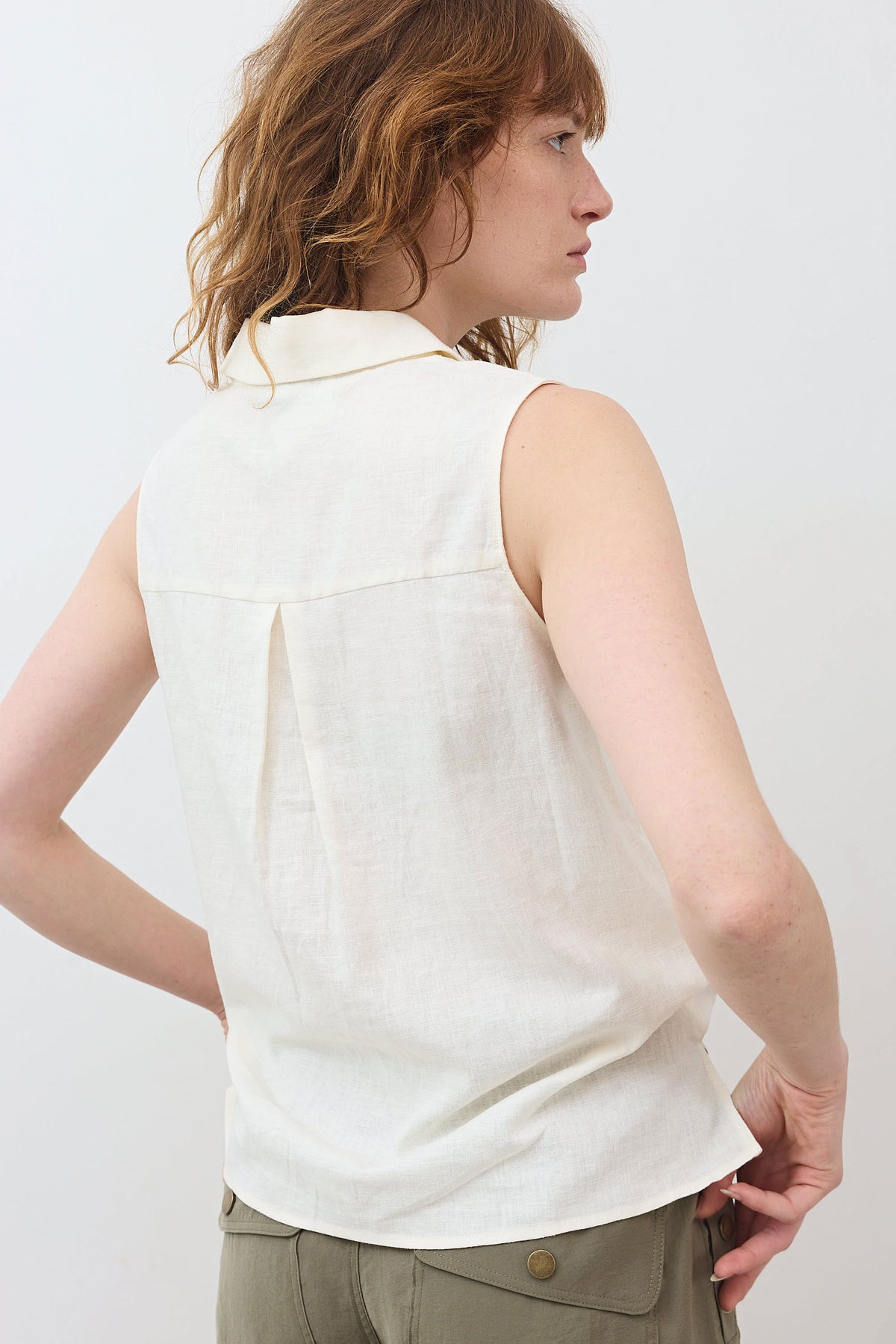 Back view of ivory sleeveless tie-front button-down shirt with yoke seam