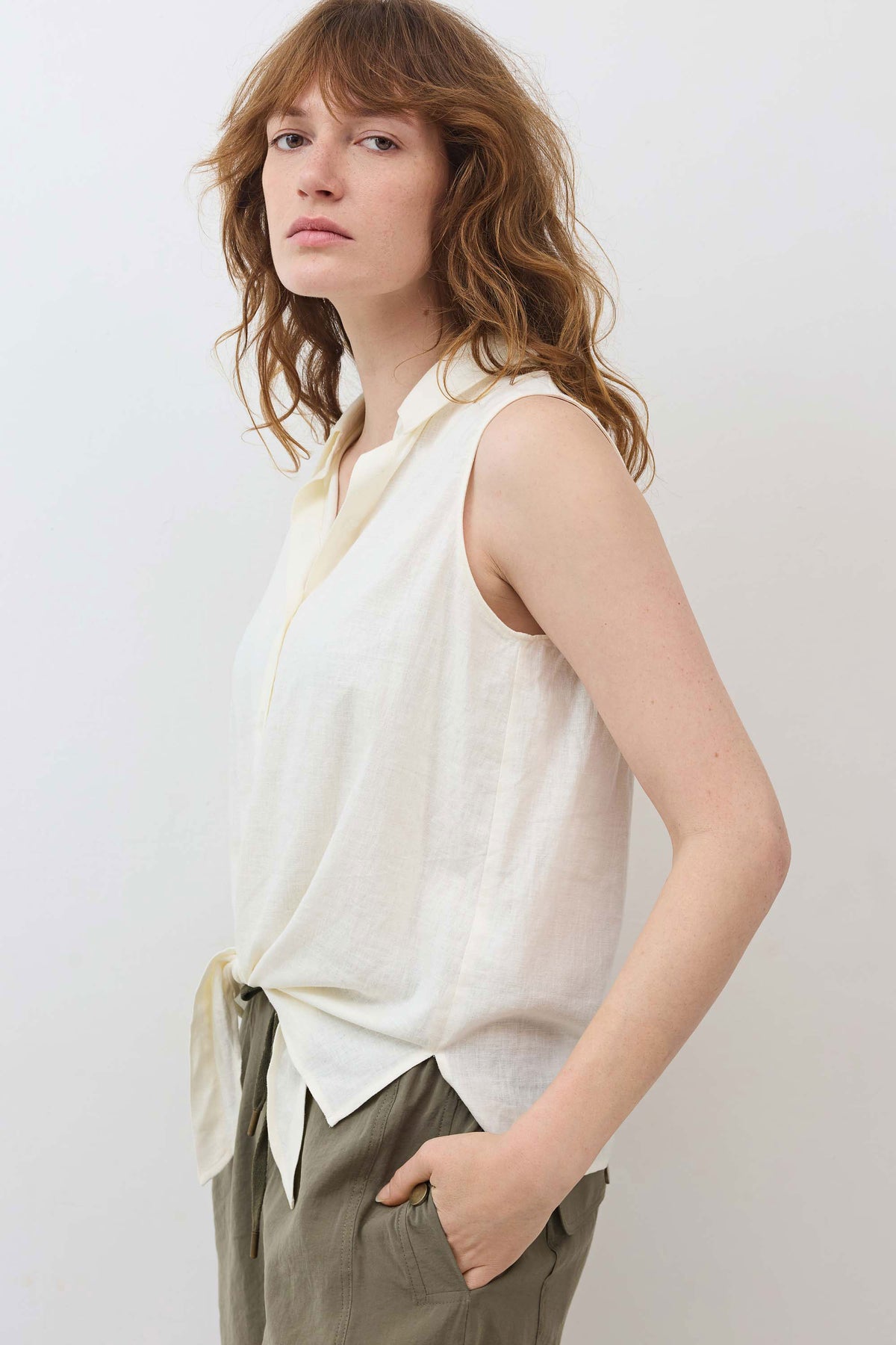 Ivory sleeveless tie-front button-down shirt with V-neck collar and tied front