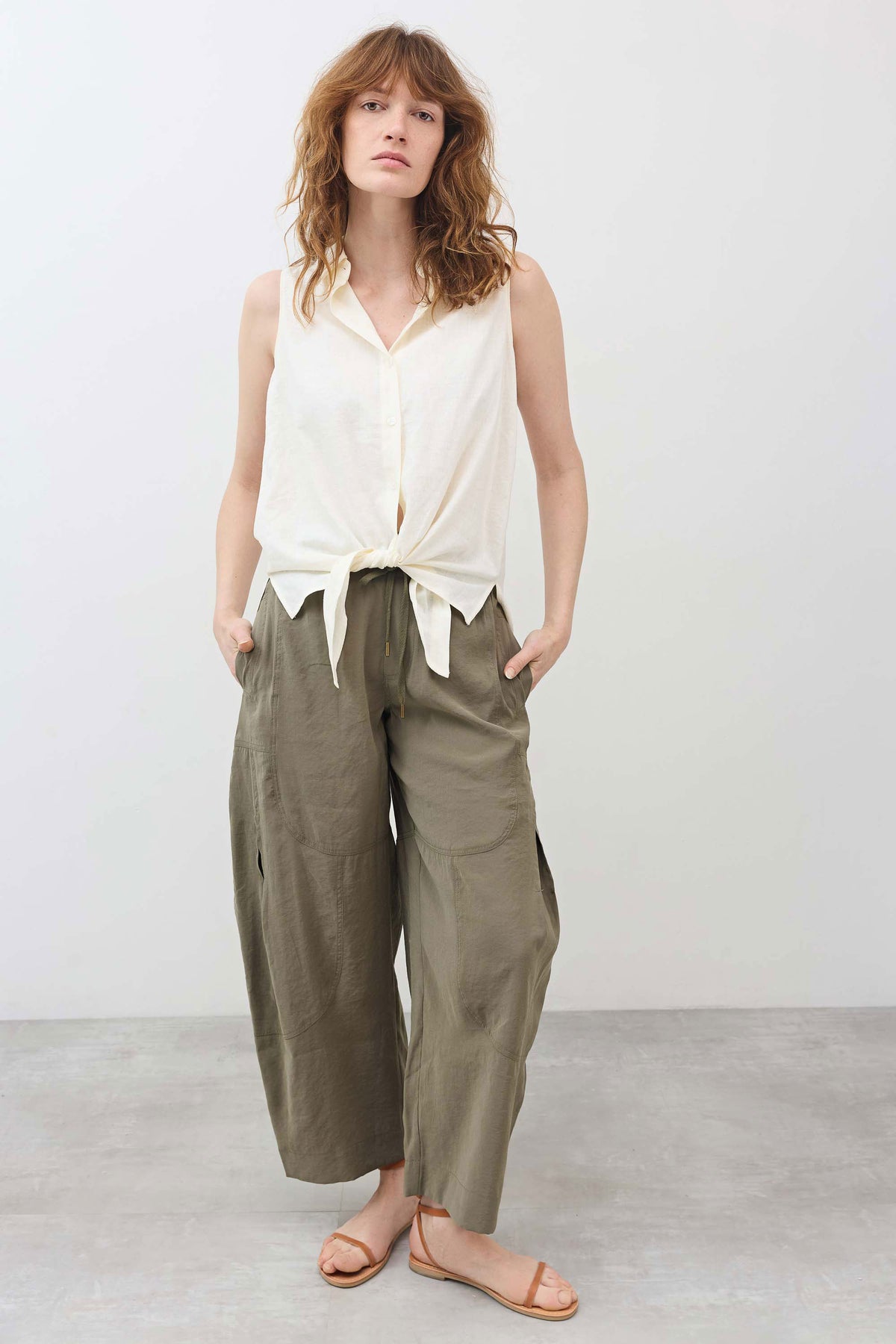 Ivory sleeveless tie-front button-down shirt with tied hem at waist
