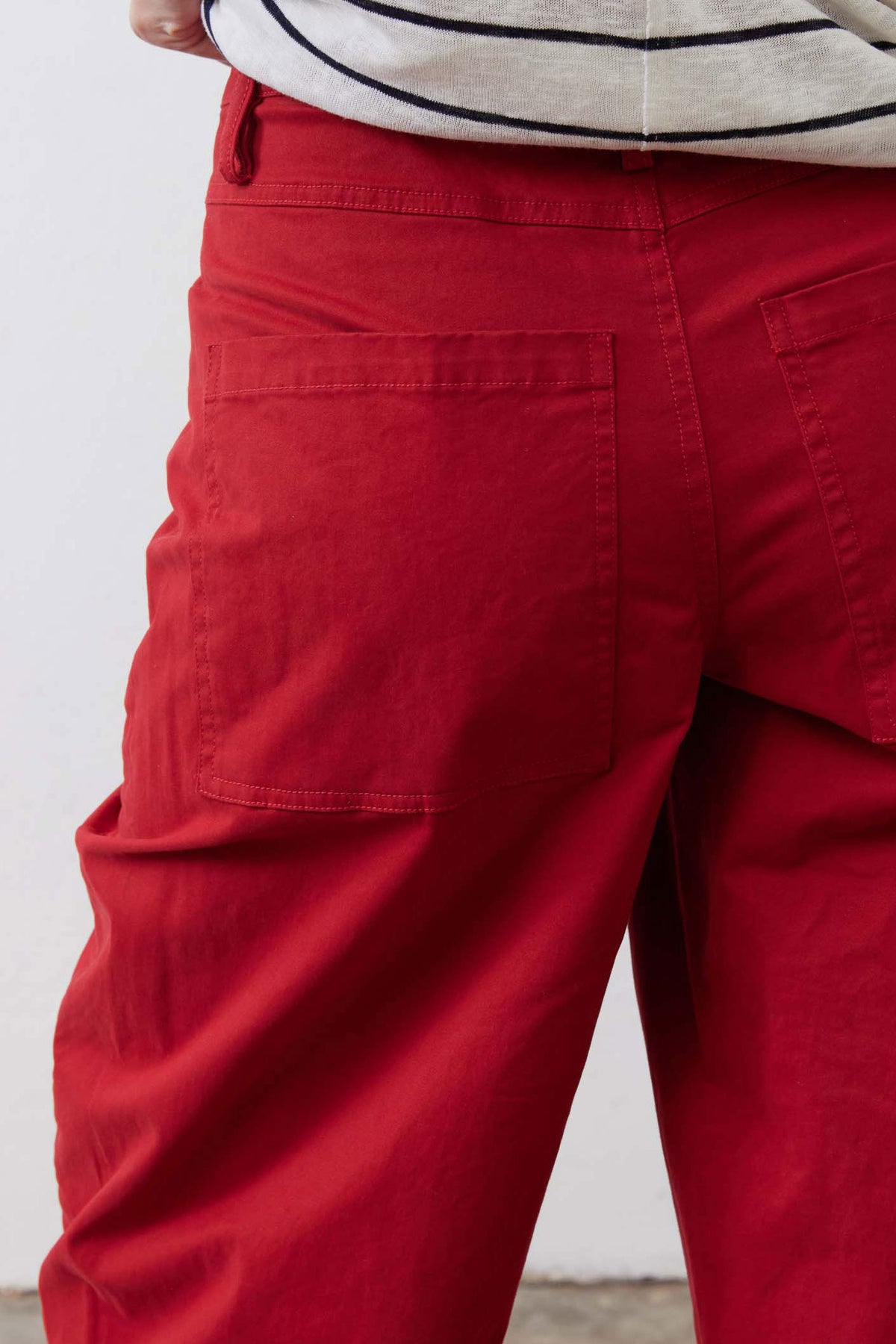 Scarlet twill pants close-up of front pockets and relaxed leg seam