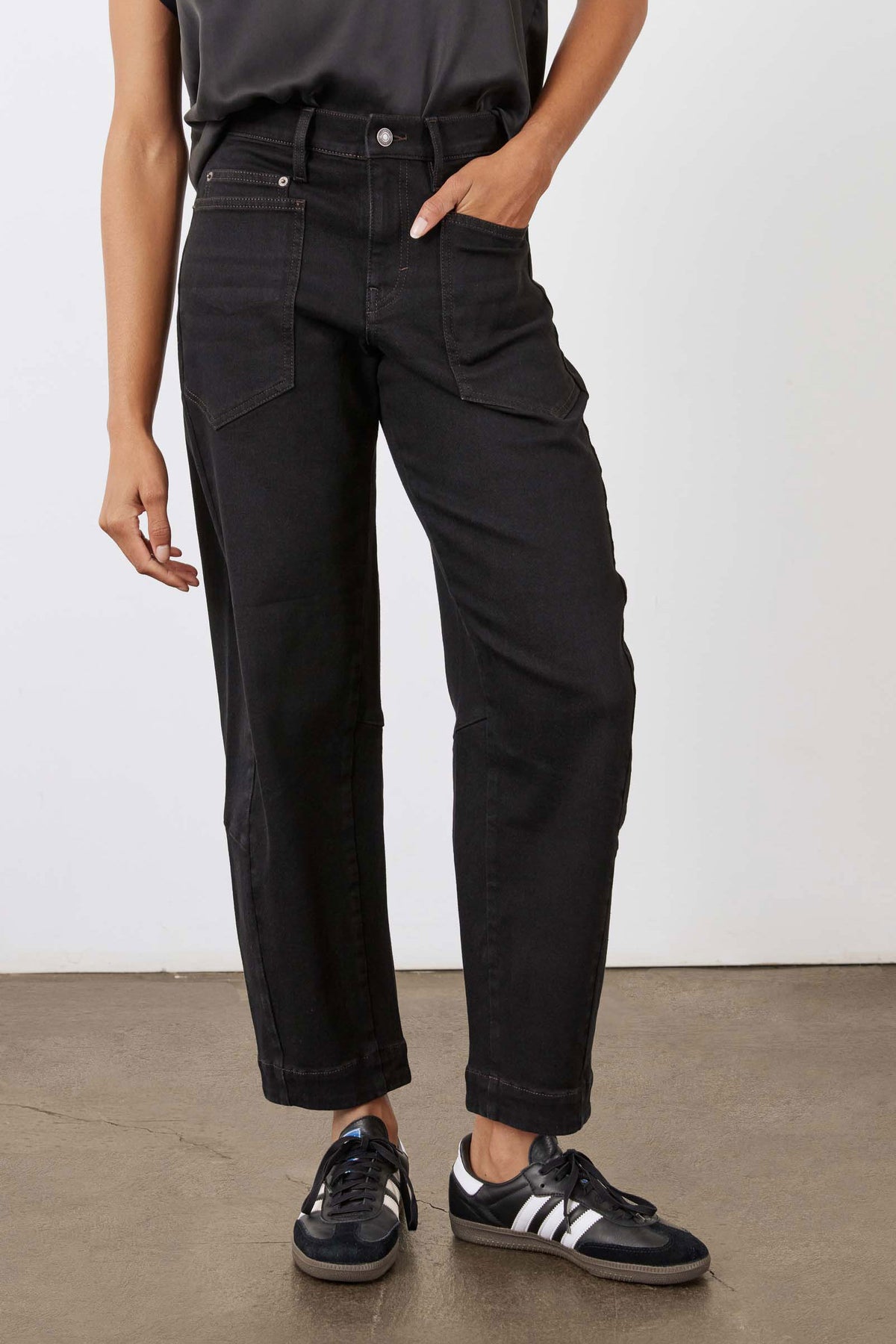 Black slouchy jeans with front patch pockets and relaxed straight-leg silhouette