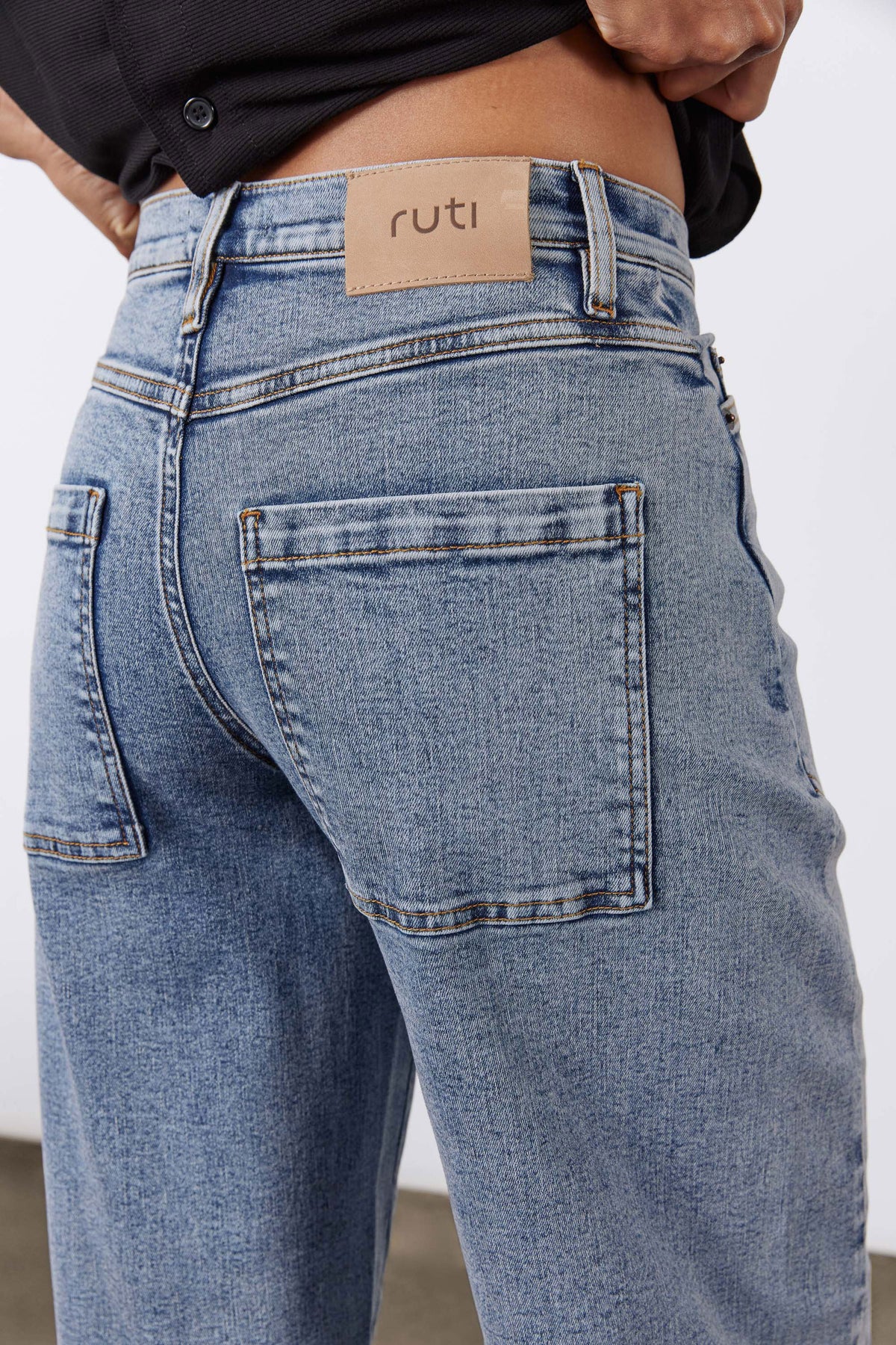 Light blue slouchy jeans with logo patch at waistband and stitched front pocket
