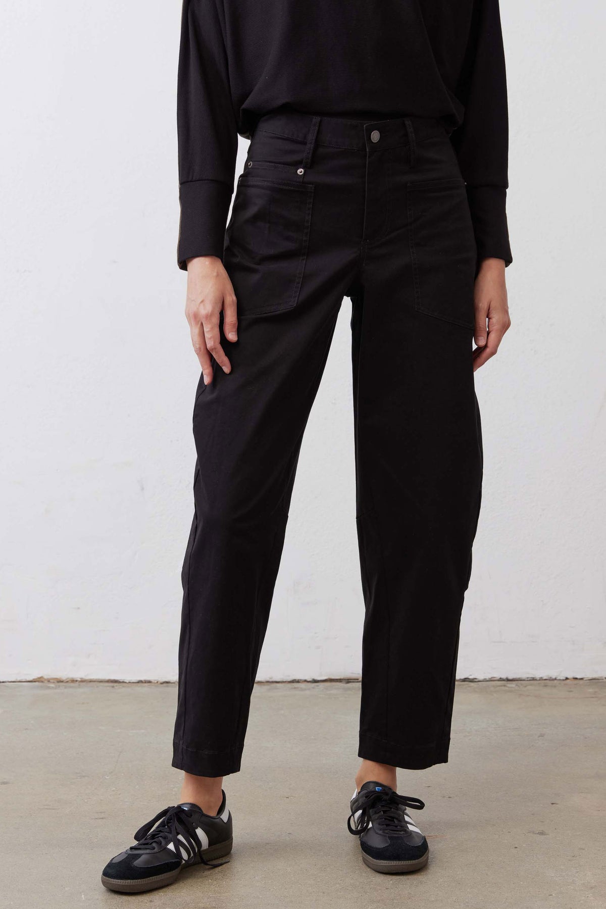 Black slouchy twill pants with front button closure and two back pockets, straight fit
