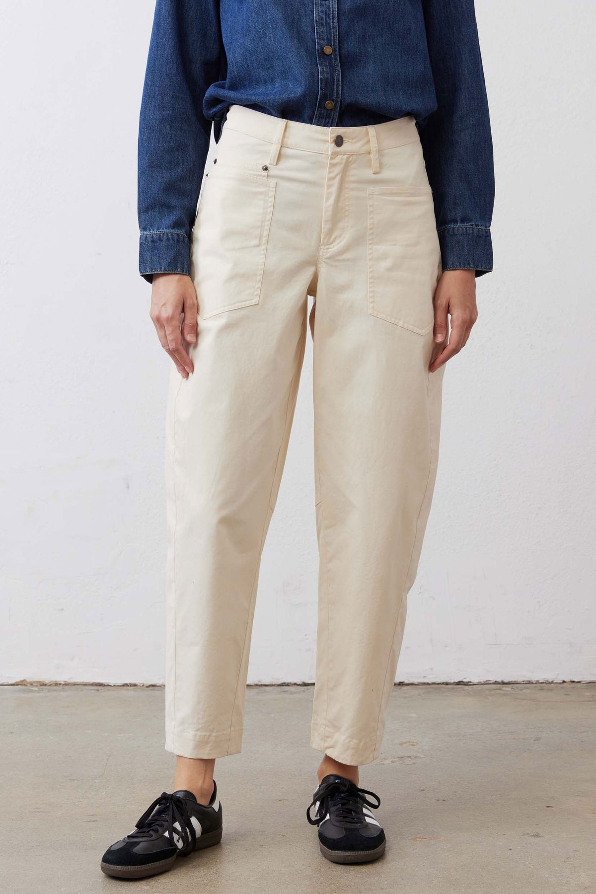 Ecru twill pants on model, relaxed through the leg with button front and pockets