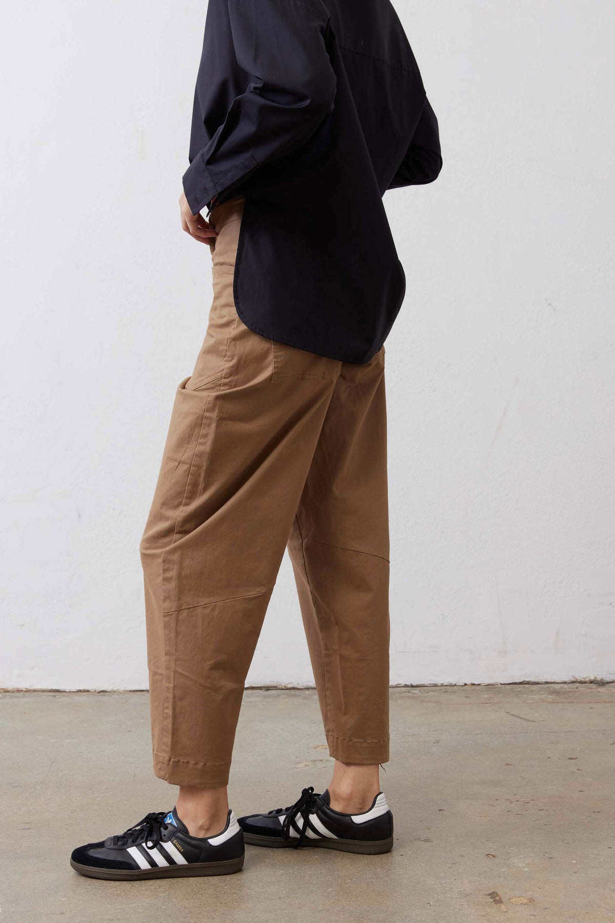 Tan slouchy twill pants with roomy fit, side pockets, and cuffed ankle hem