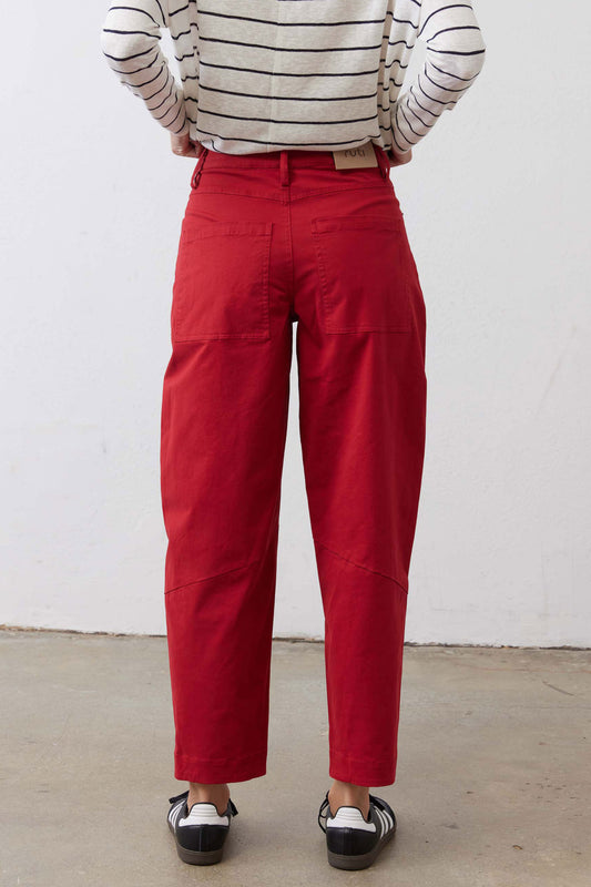 Scarlet twill pants with tapered legs, stitched seams, and wide belt loops at waist