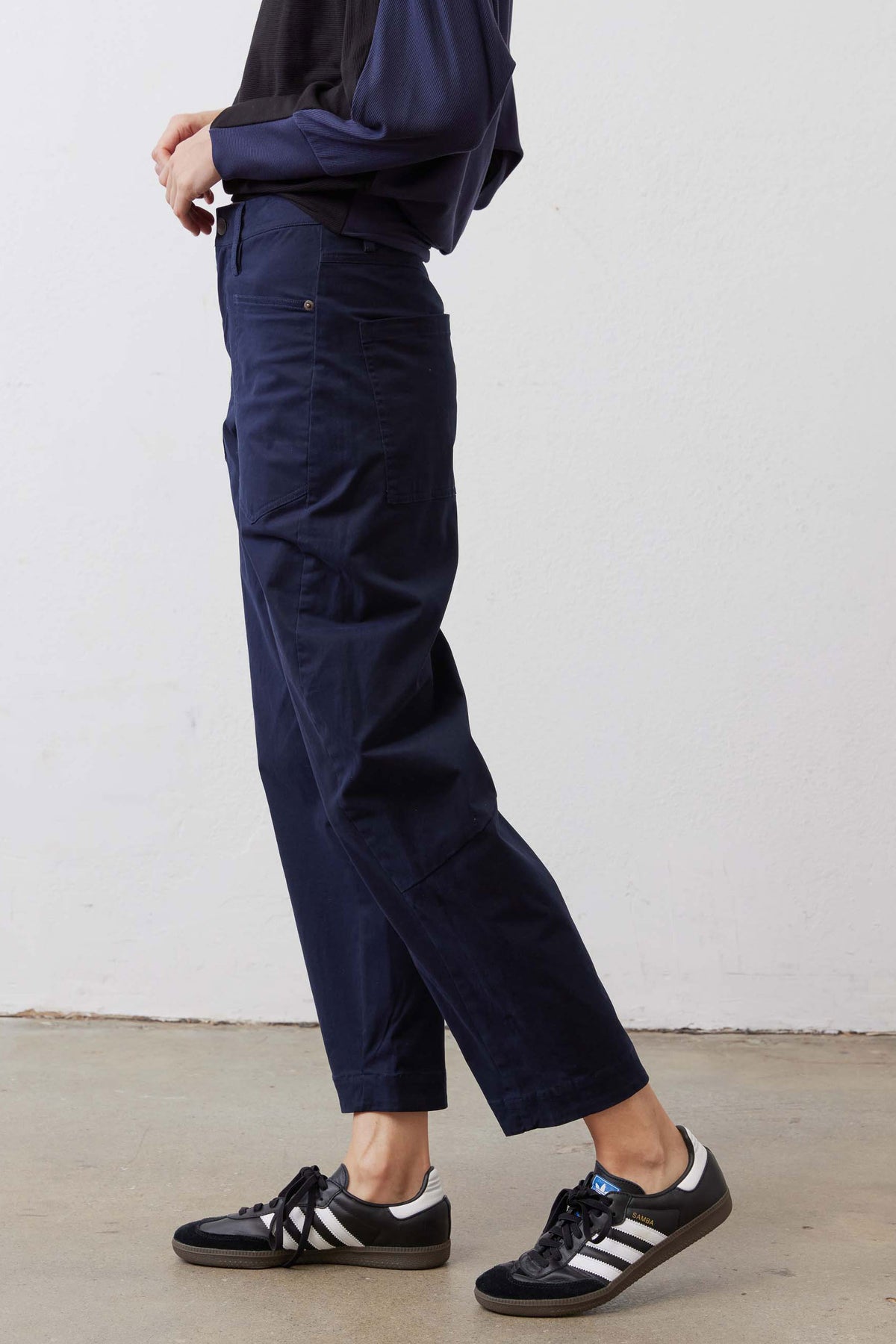 Washed navy twill pants in profile view, relaxed fit, cuffed hem, side pockets