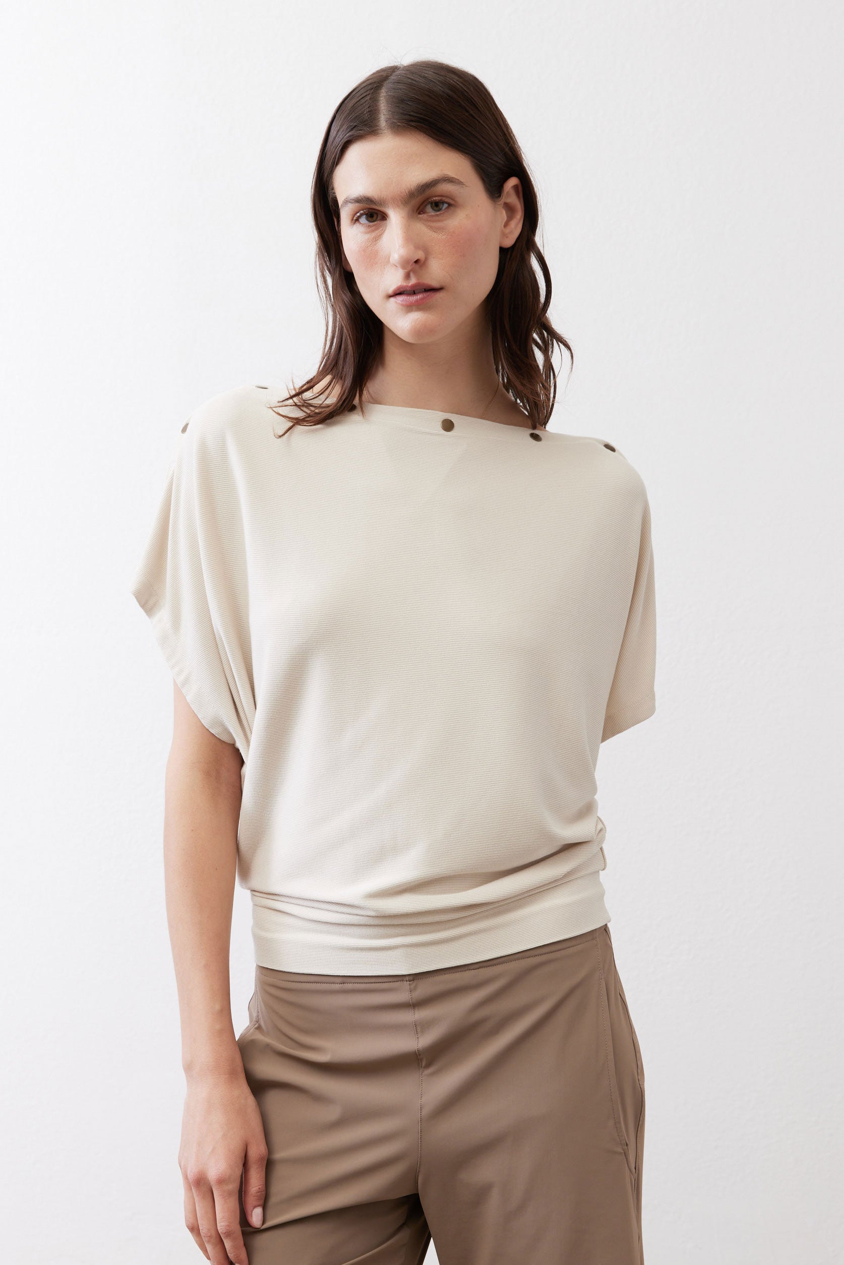 Cream short-sleeve top with round neckline and snap-button shoulder detail
