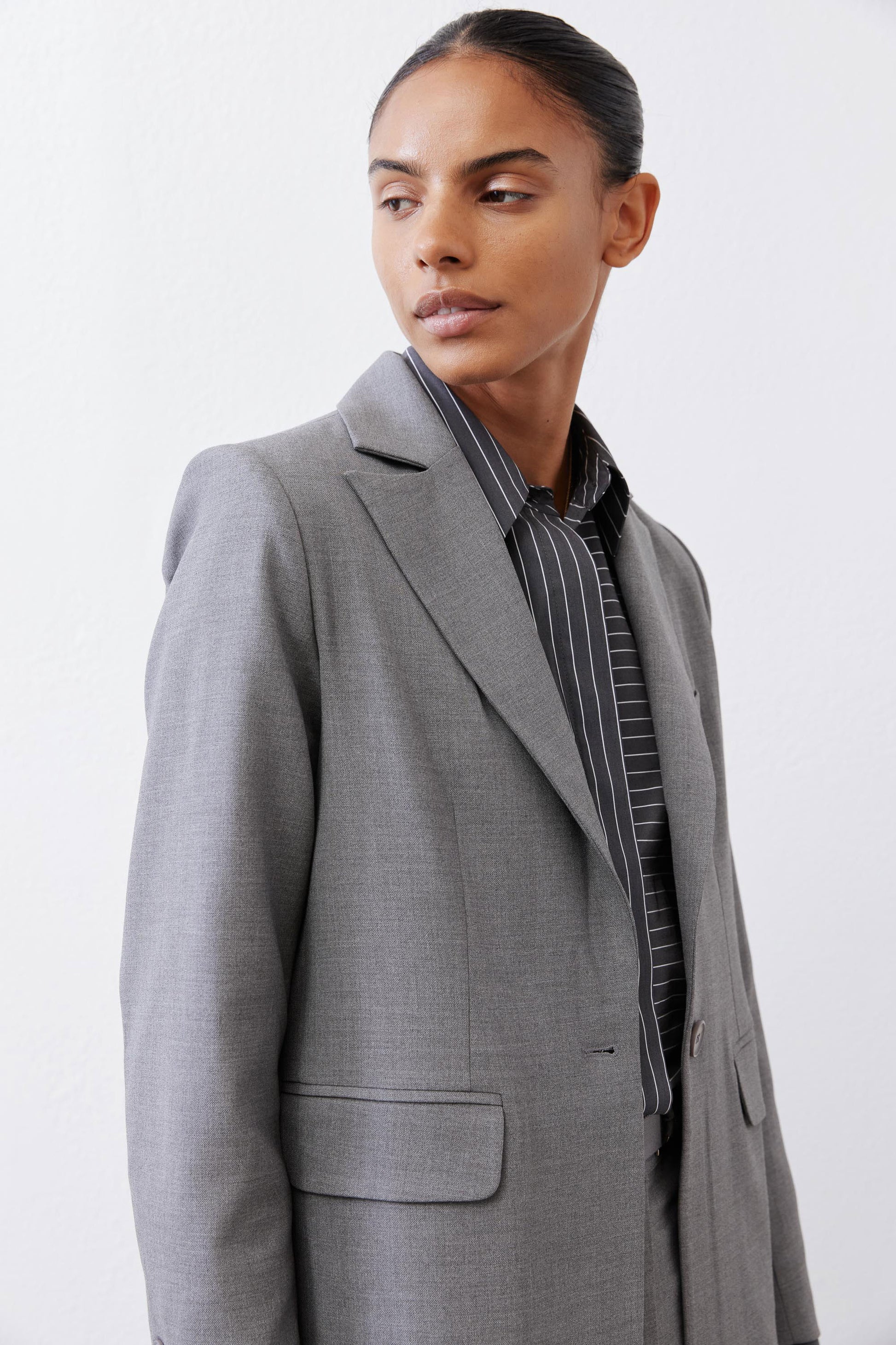 Gray melange squared off blazer front view with square lapels and flap pockets