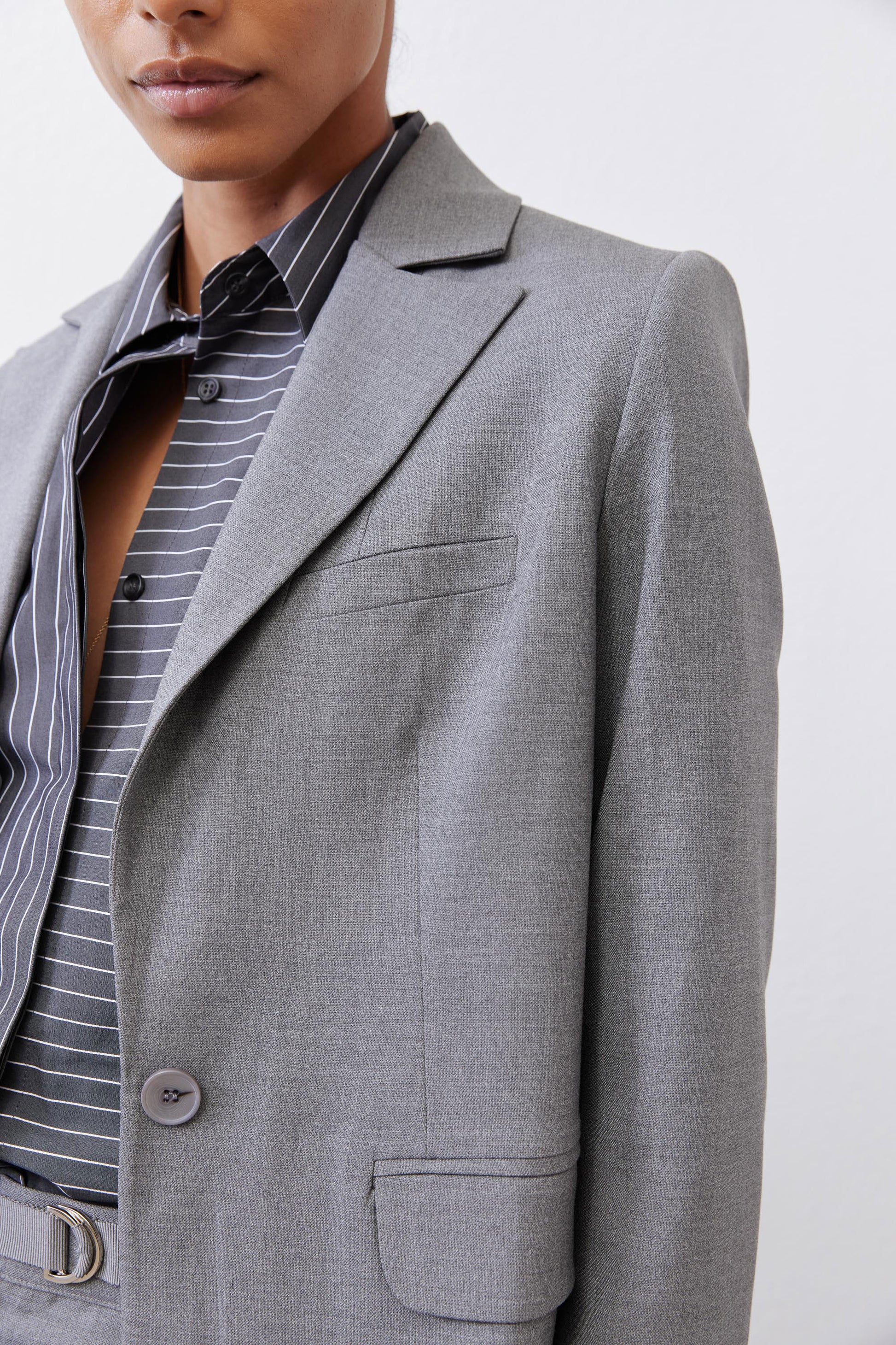 Gray melange blazer close-up of square lapel and chest flap pocket with button