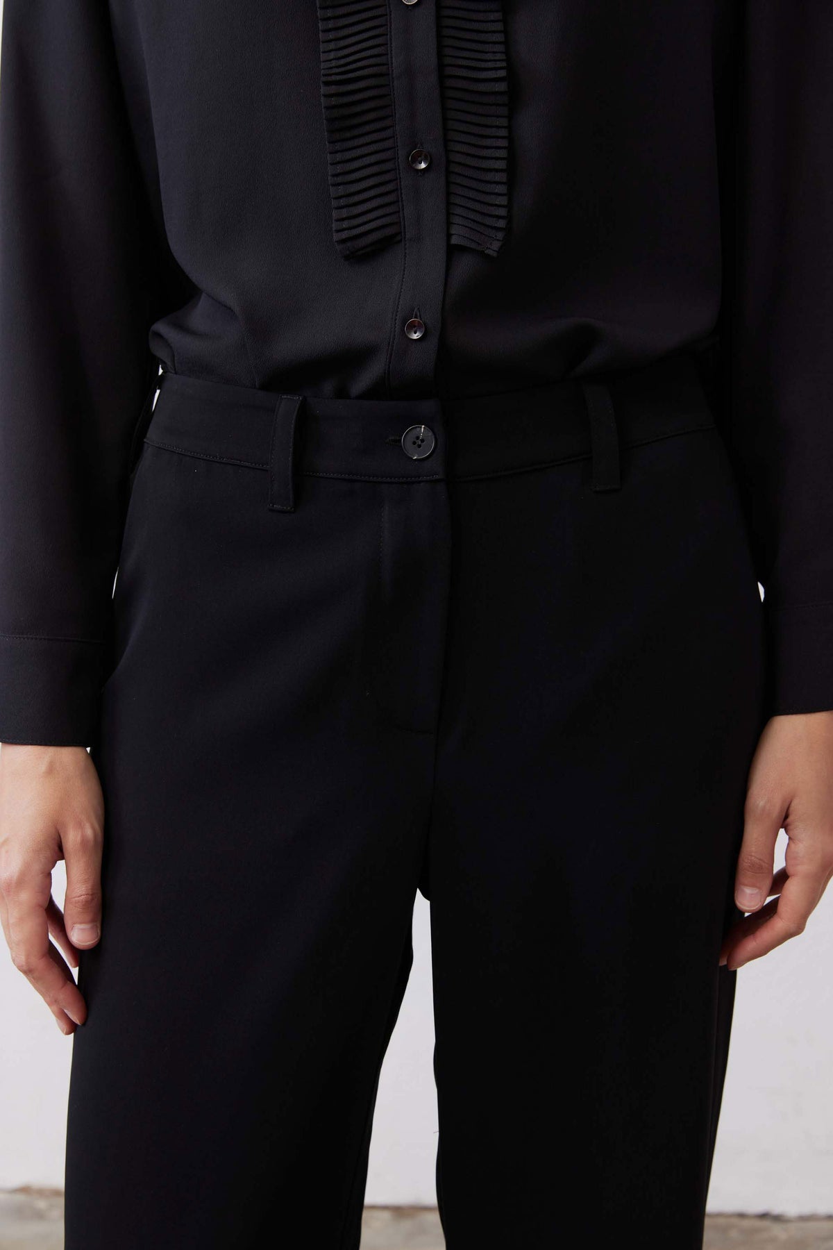 Black straight-leg pants front with button closure and flap pockets