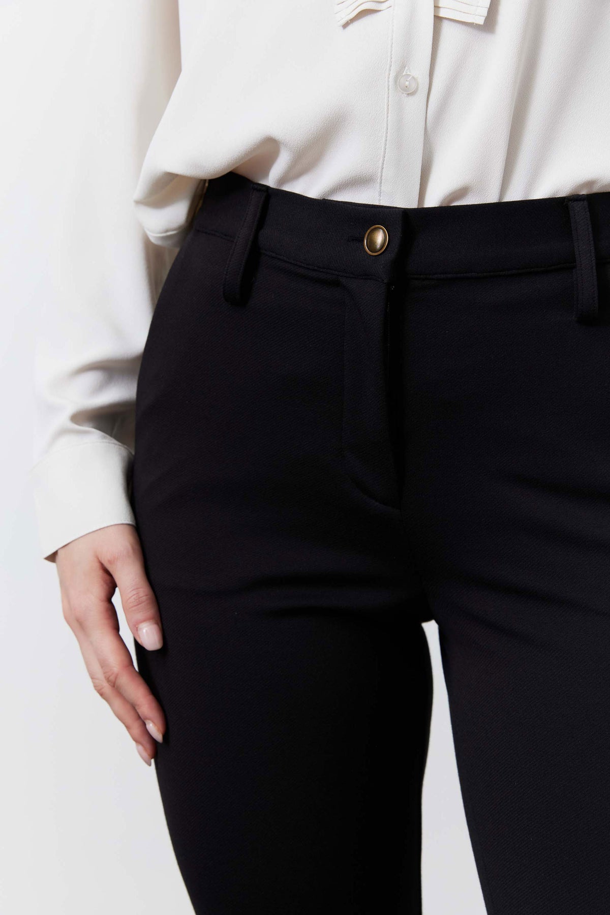 Black tapered suit pants close-up of waistband with button and belt loop