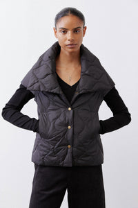 Black quilted down vest with stand collar and gold snap buttons