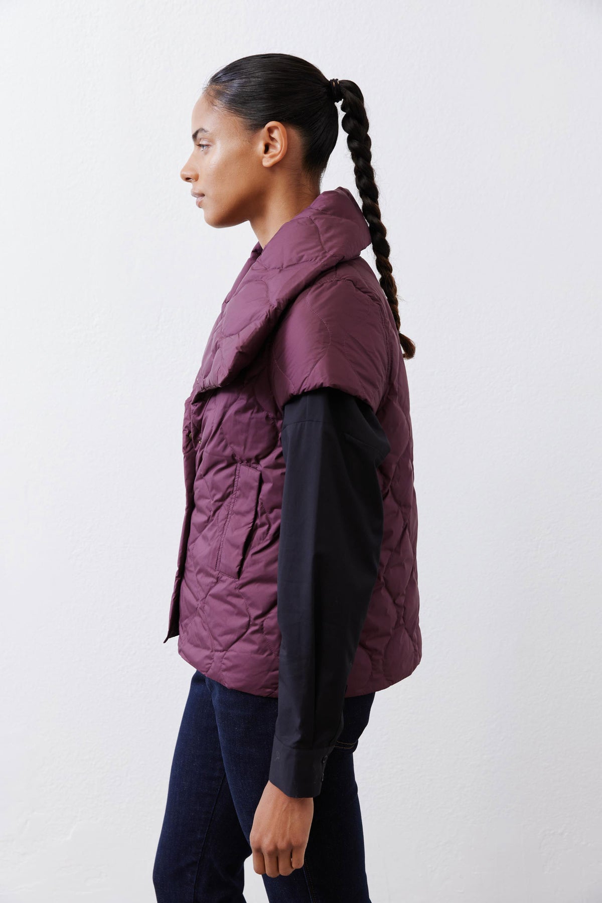 Deep plum quilted down vest side view with quilted texture and snap front