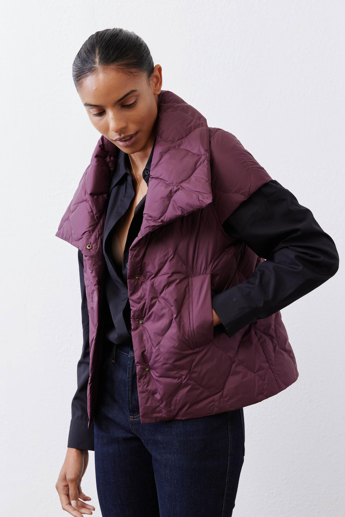 Deep plum quilted down vest angled view with stand collar and front pocket seam