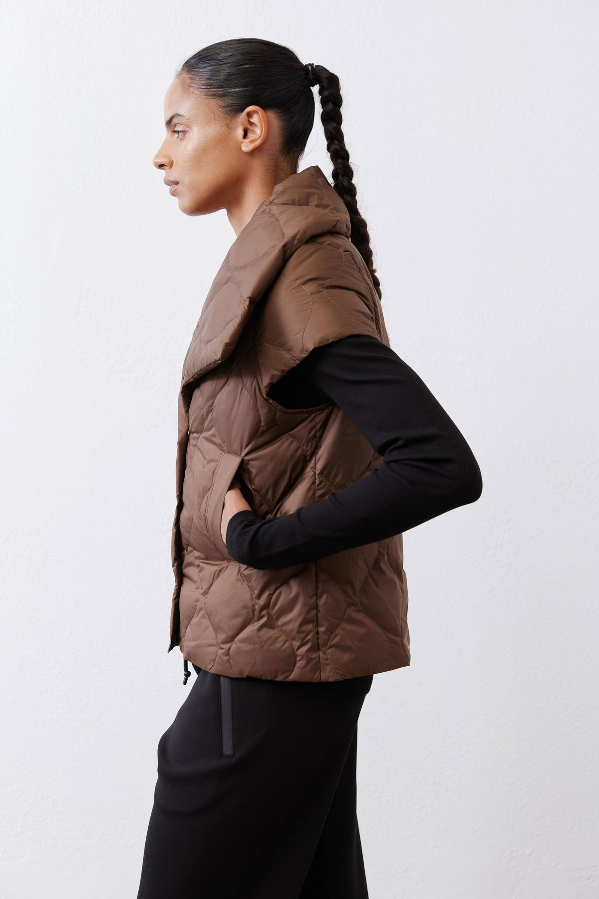 Coffee brown quilted down vest with stand collar and button closure, side view