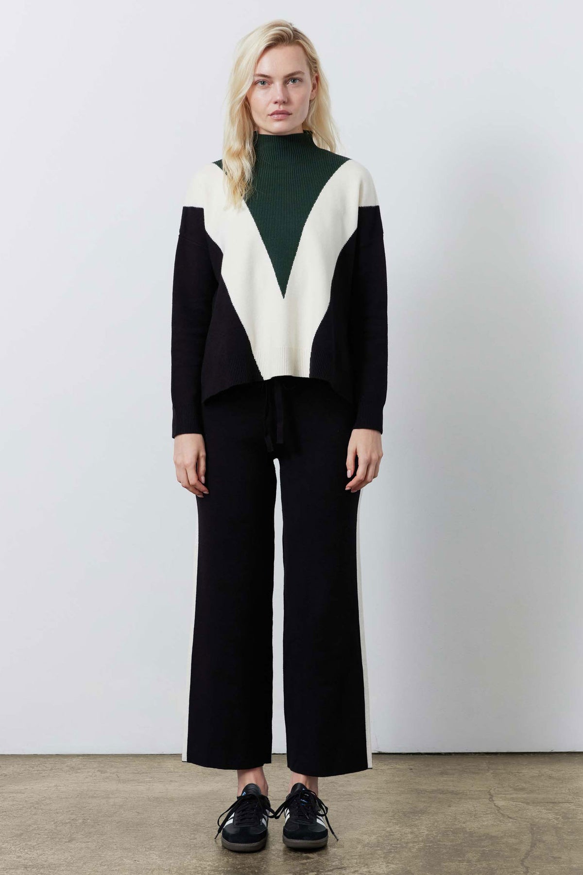 Black lounge pants with tall ivory side stripe and wide straight-leg cut