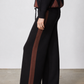 Black wide-leg lounge pants with brown vertical side stripe