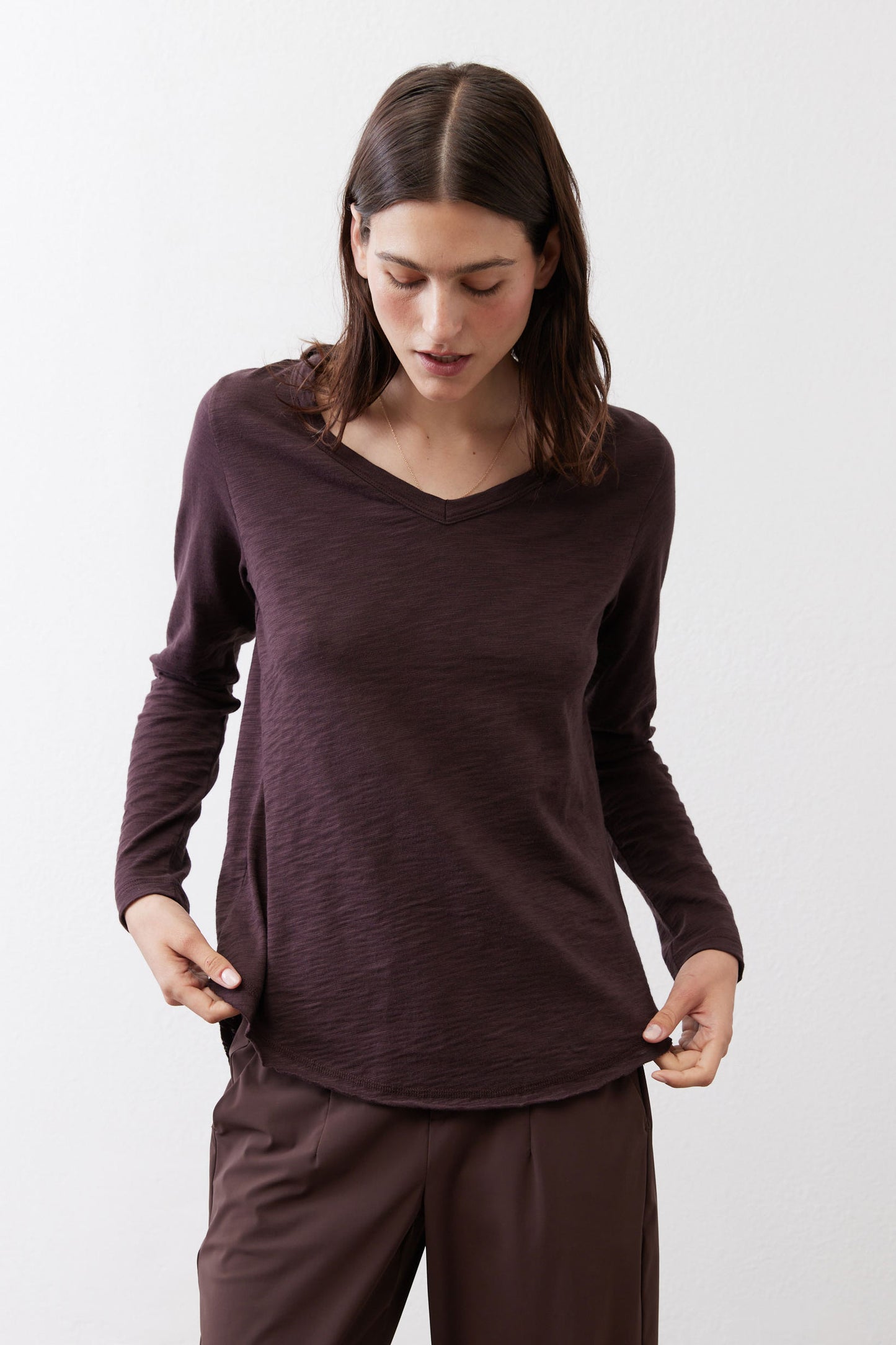 Coffee-brown V-neck long-sleeve top with loose drape and curved hem
