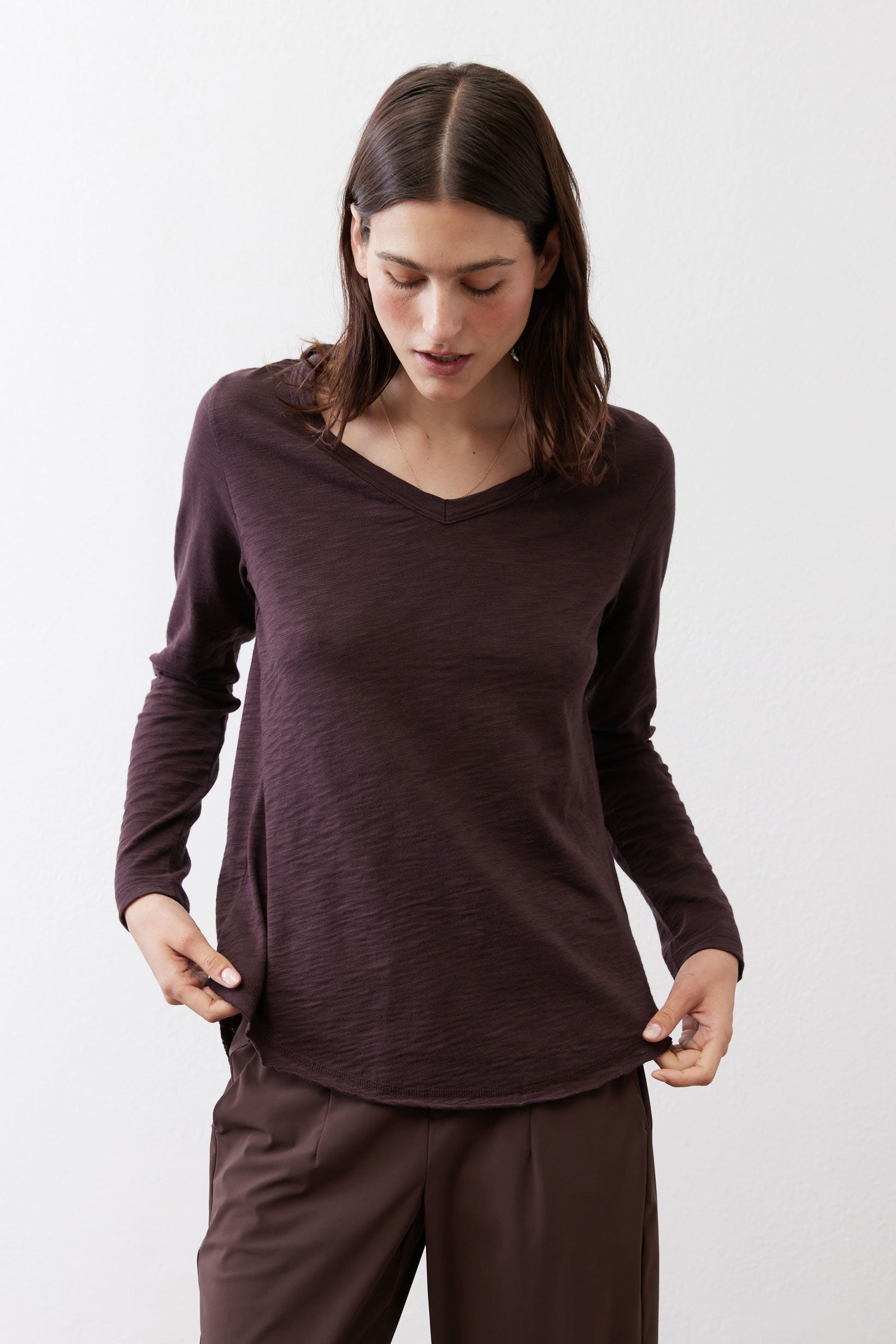 Coffee-brown V-neck long-sleeve top with loose drape and curved hem
