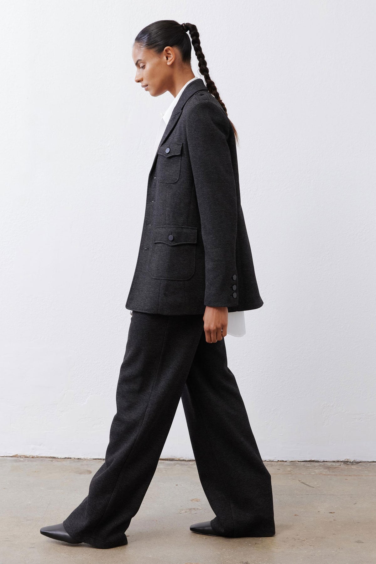 Charcoal herringbone blazer, side profile with flap pockets and buttons