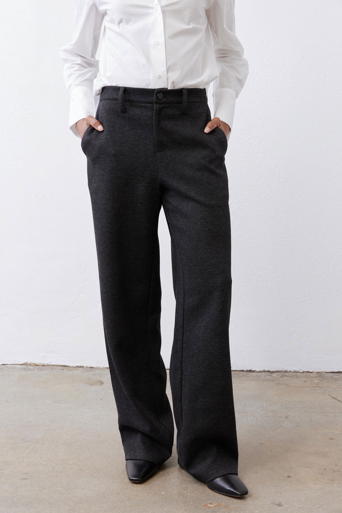 Charcoal straight-leg tailored pants, front close-up with button waist and pockets