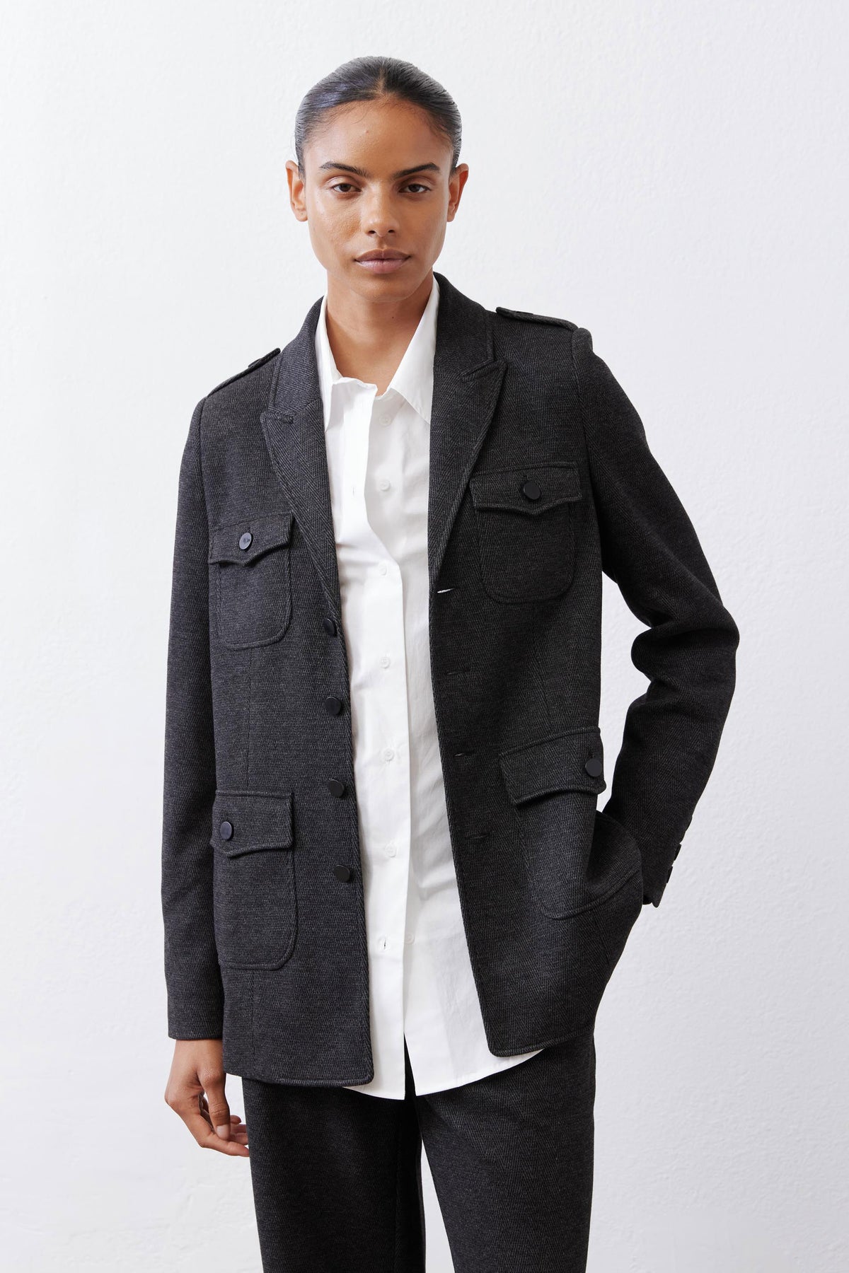 Charcoal herringbone blazer with flap chest pockets and button placket