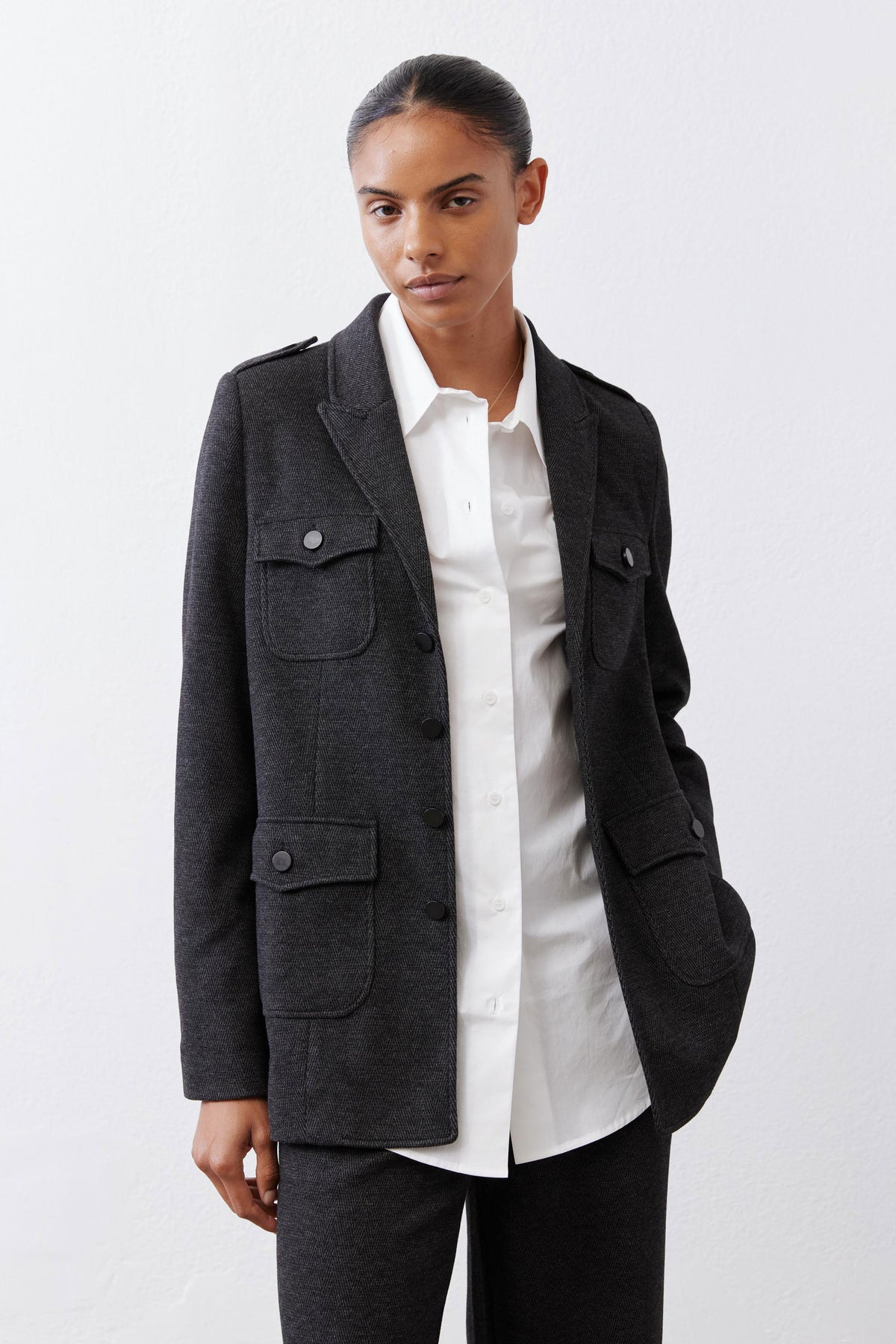 Charcoal herringbone blazer with two flap pockets and button details