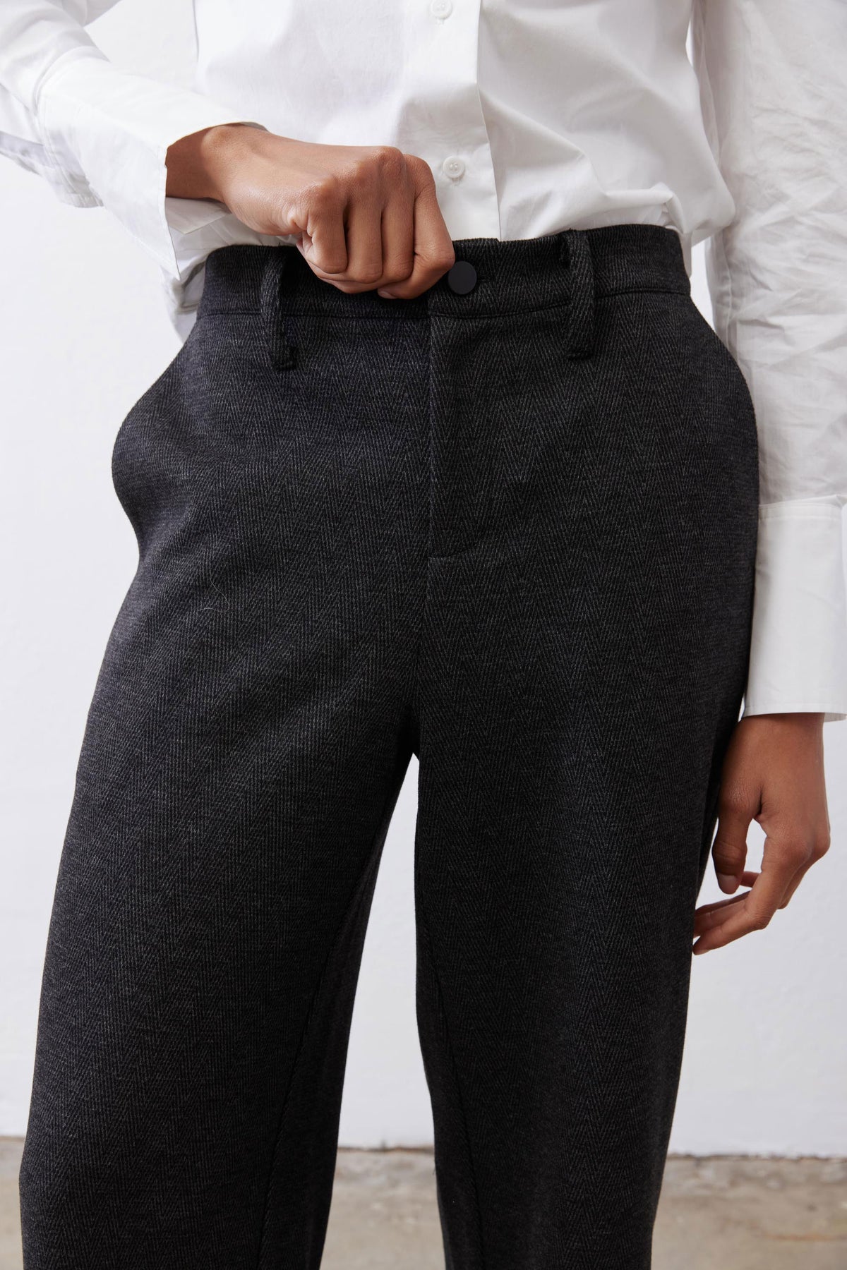 Charcoal straight-leg pants close-up with button waist and belt loops
