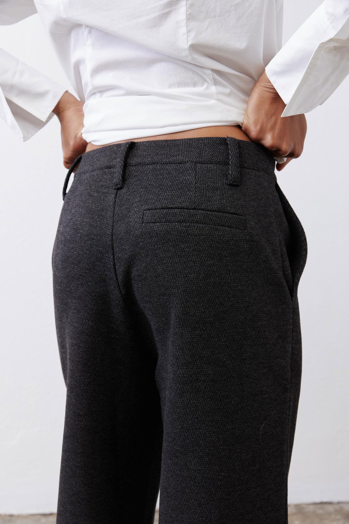 Charcoal tailored pants waistband detail with belt loops and back pocket flap