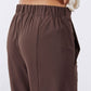 Coffee-brown pants with gathered elastic waistband and front seam