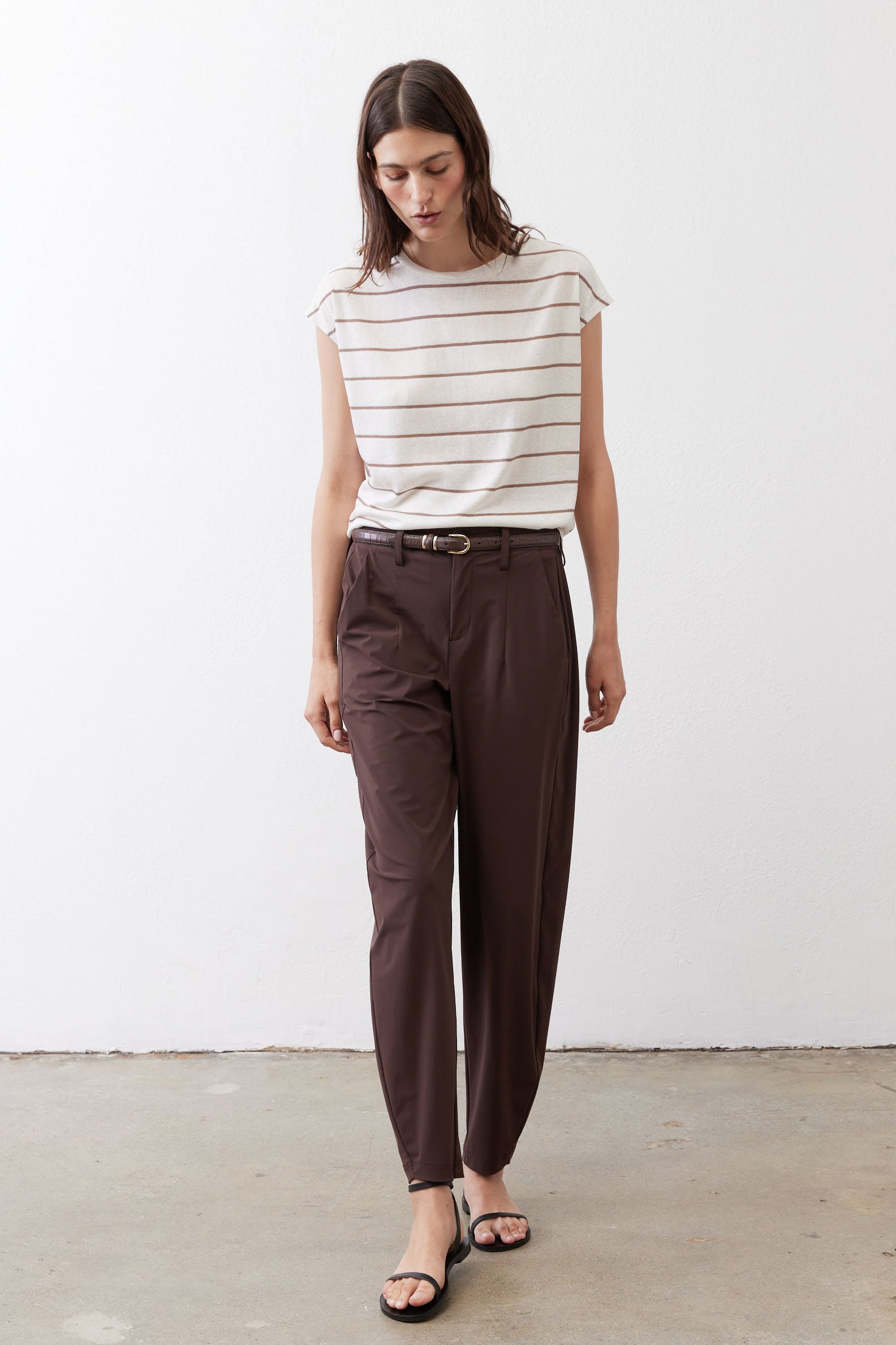 Off-white striped T-shirt with brown horizontal lines, short cap sleeves, tucked.