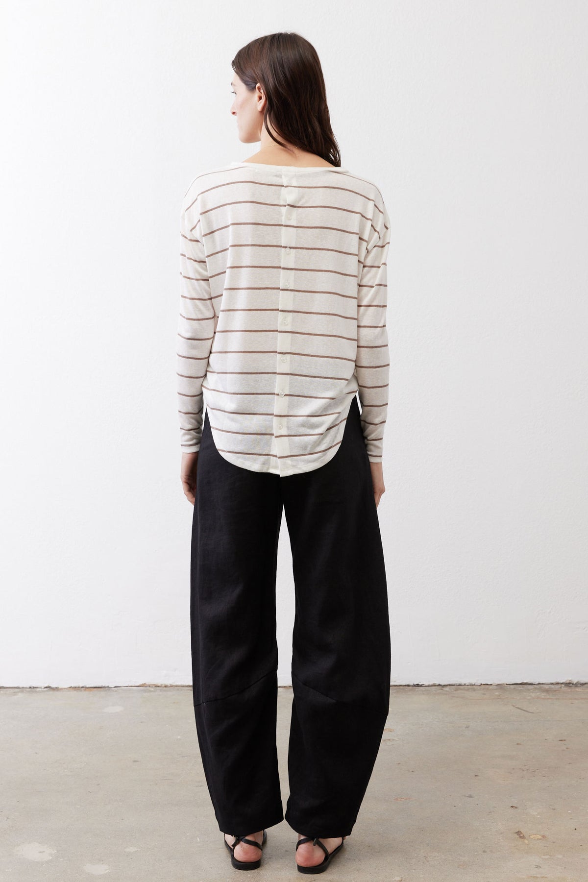 Striped long-sleeve top shown from back, off-white with tan and red stripes, button placket.