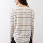 Striped long-sleeve top viewed from the back with button detail at the upper back