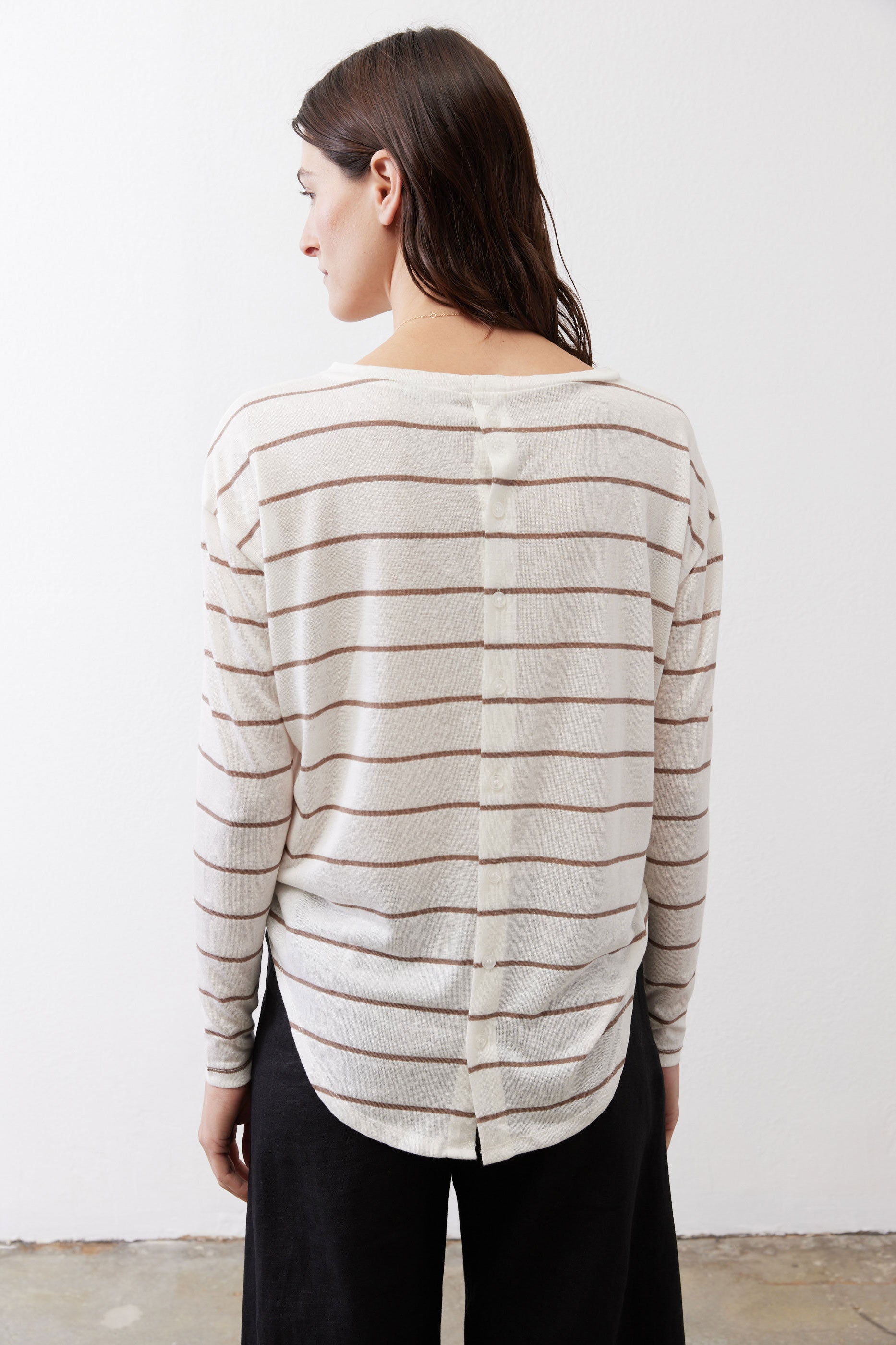 Striped long-sleeve top viewed from the back with button detail at the upper back