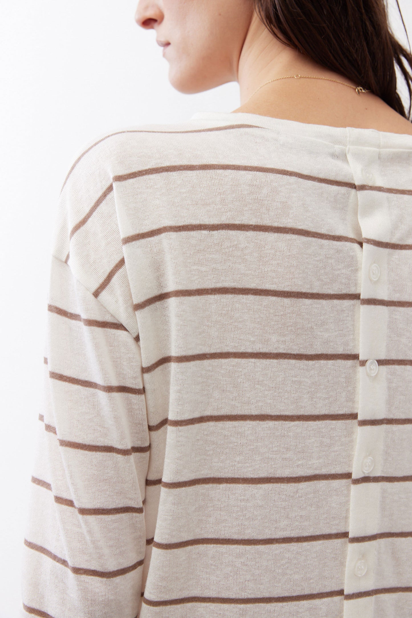 Back of striped long-sleeve top with horizontal tan lines and button placket