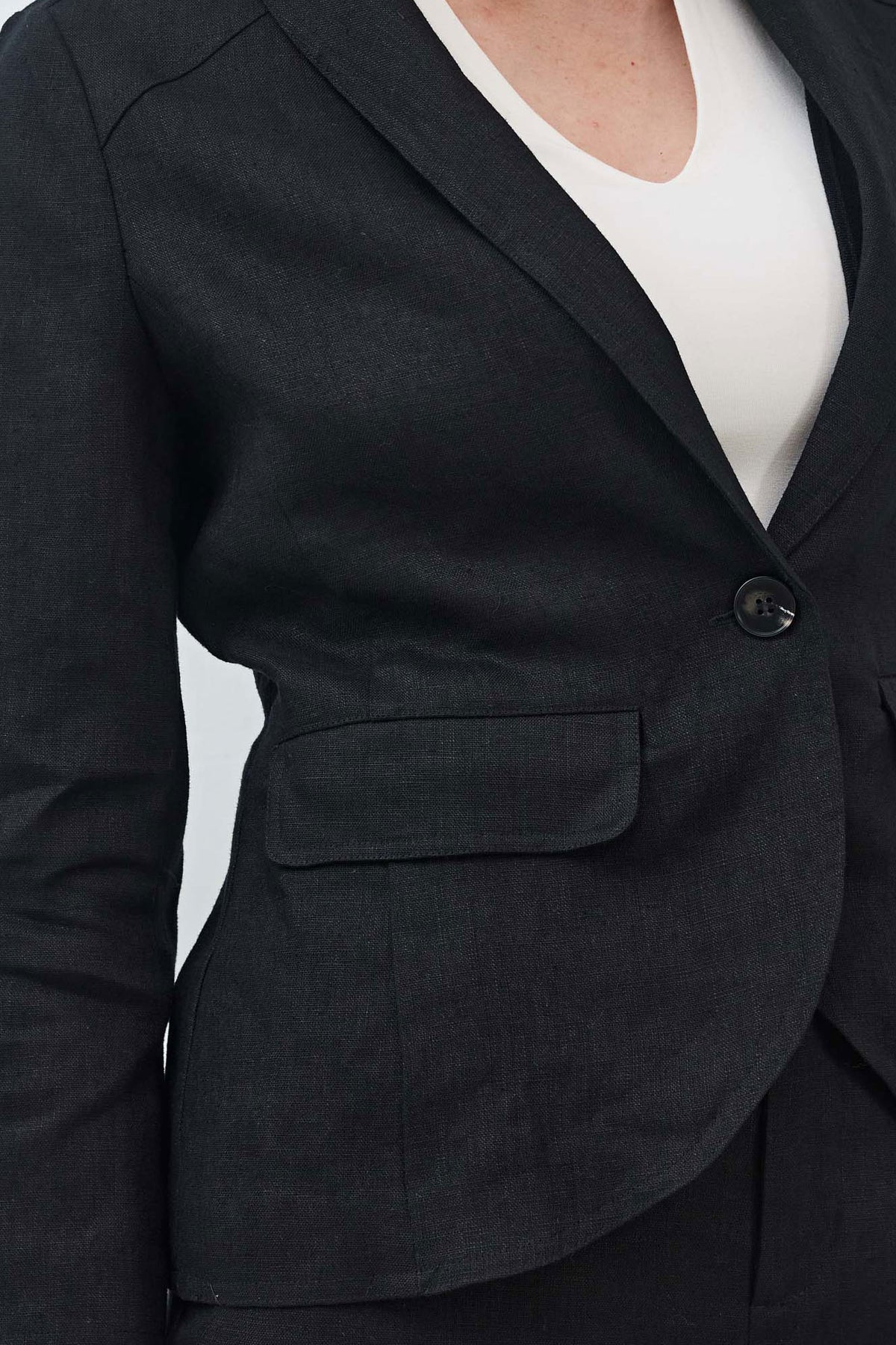 Black blazer detail with single button and flap pocket at the front