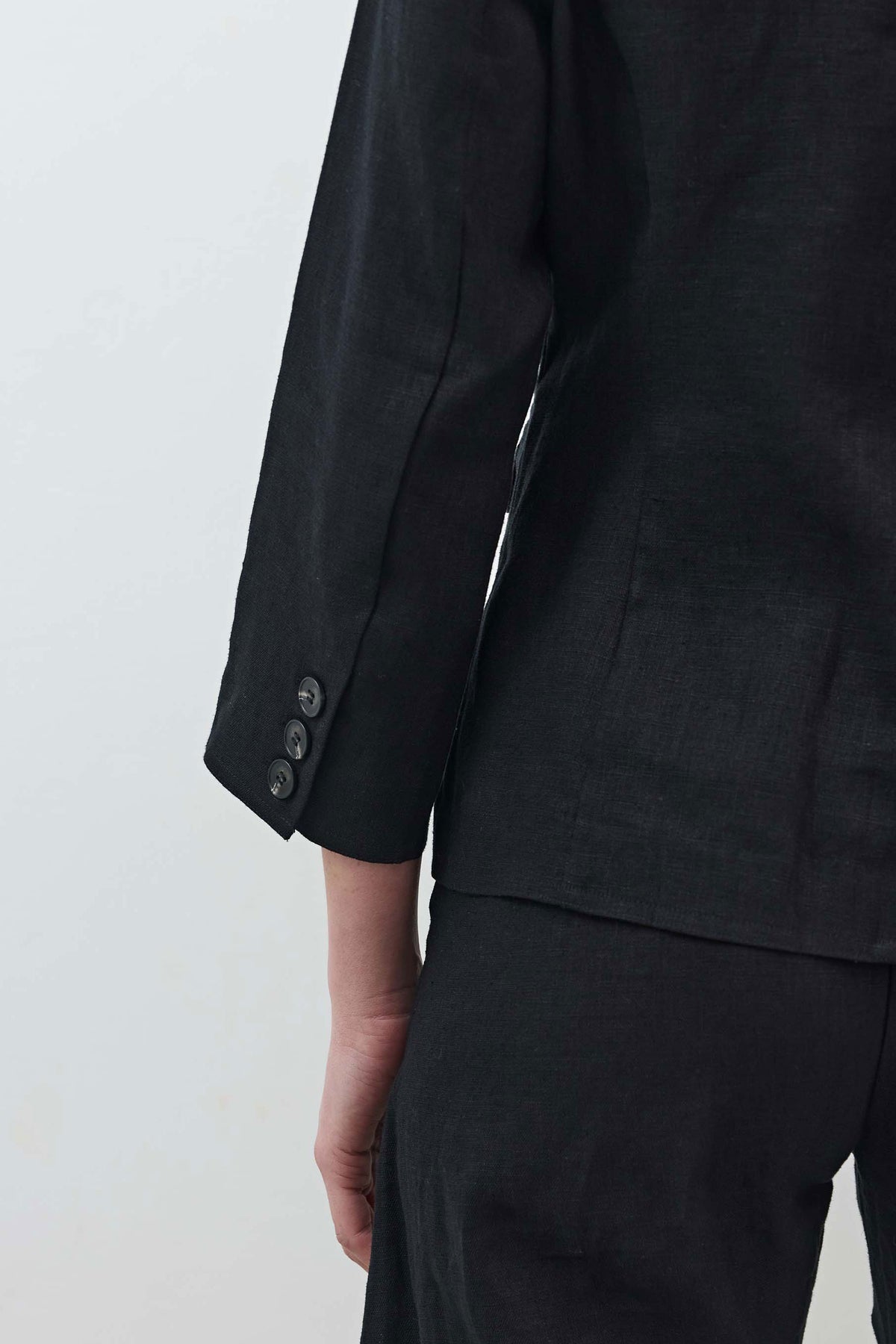 Black blazer sleeve with cuff and two buttons, side view