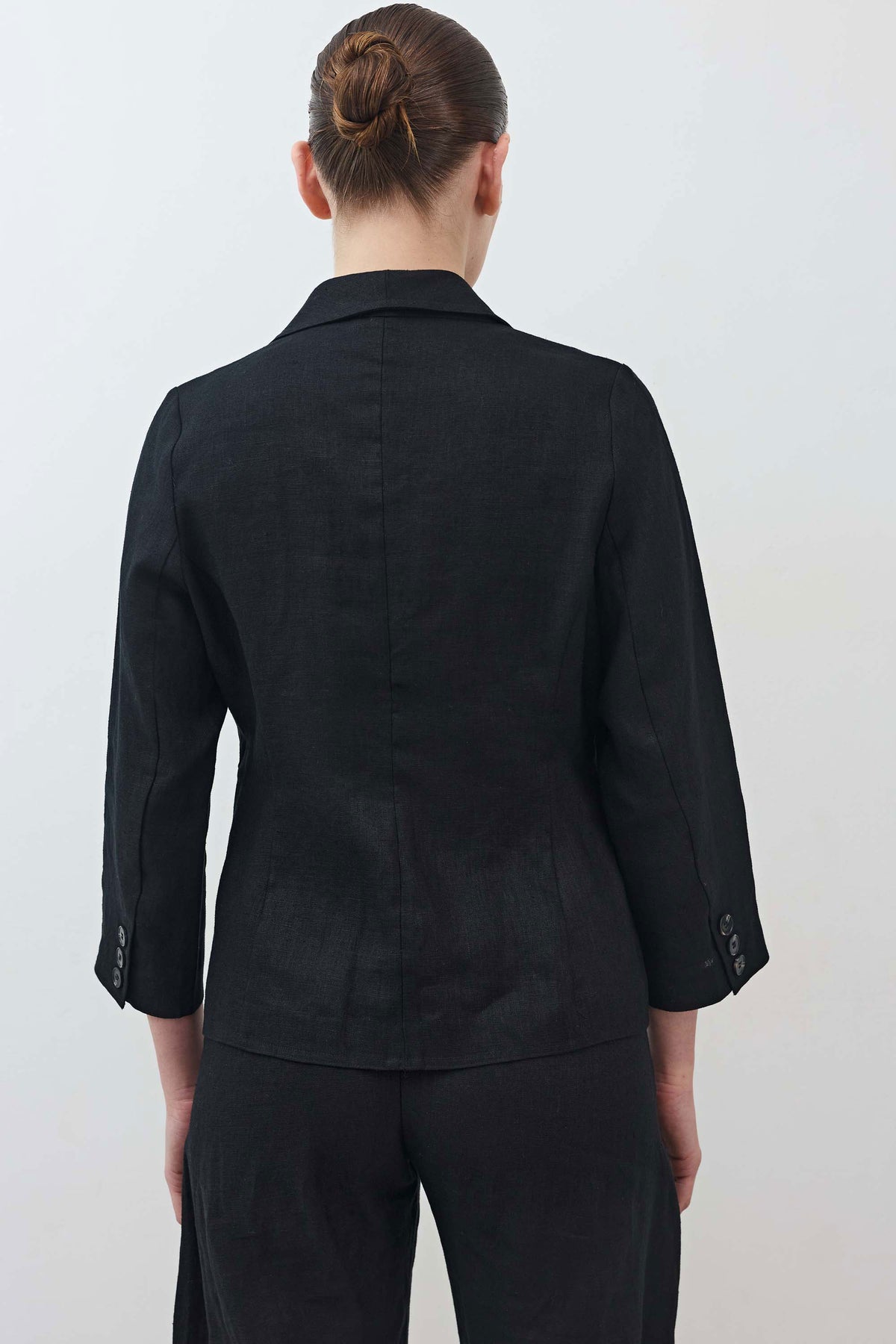 Black cropped blazer back view with three-quarter sleeves and center seam