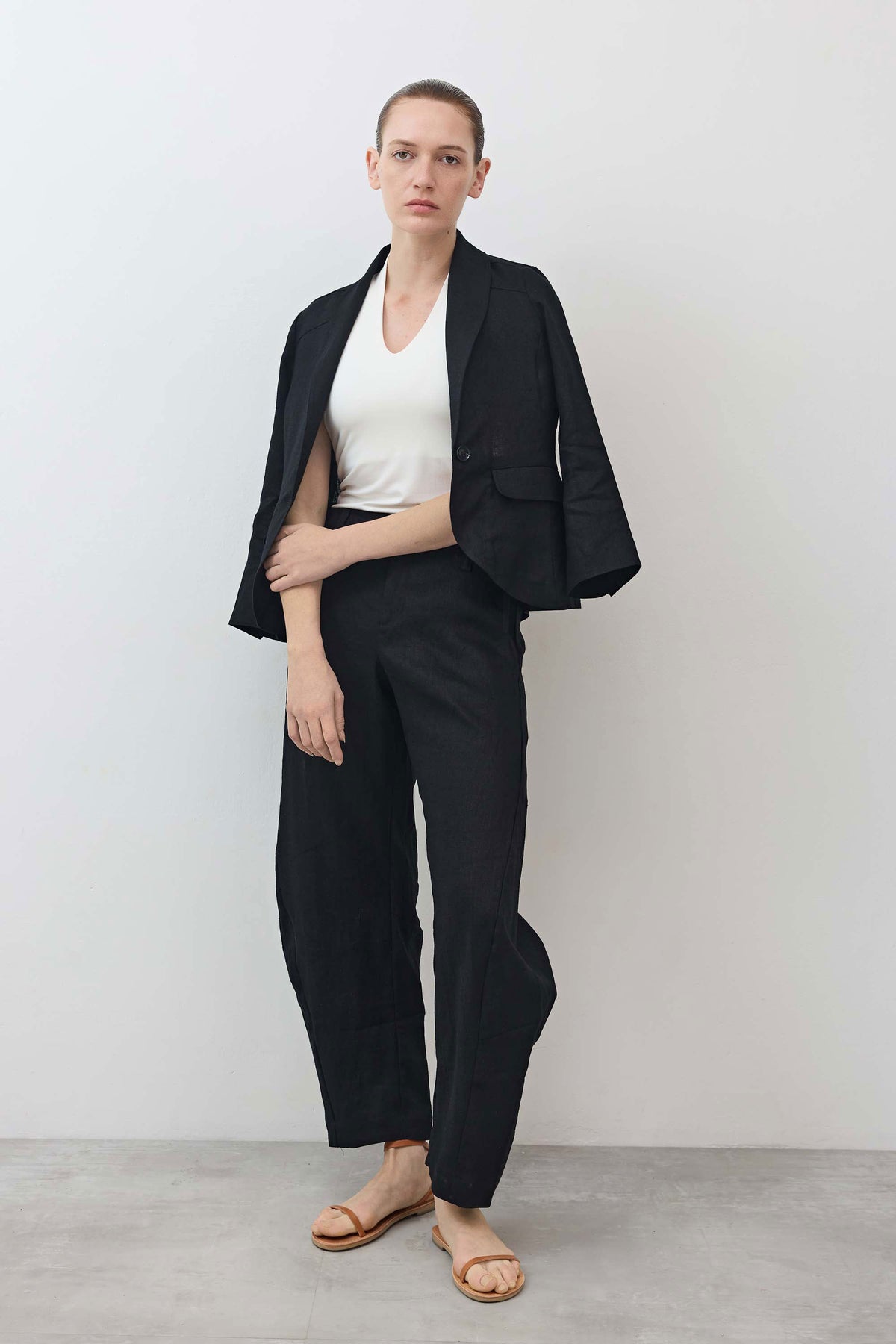 Black cropped tulip-hem blazer, open front with notch lapels and flap pockets
