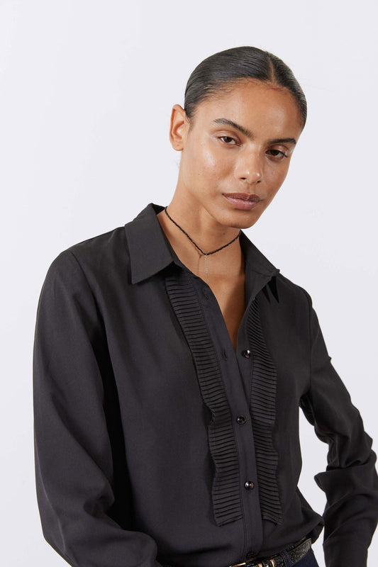 Black tuxedo-style blouse with pointed collar and button-front placket detail