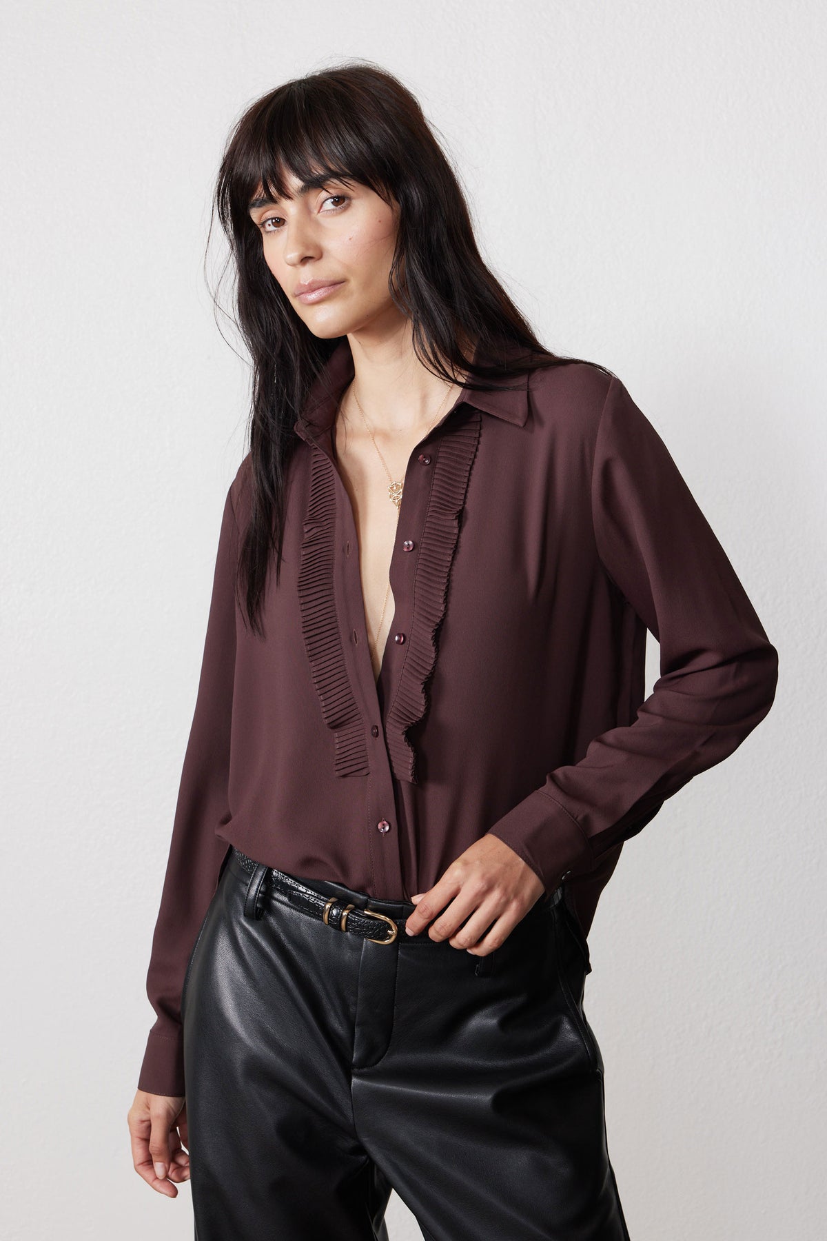 Dark brown blouse close-up with button placket and striped ruffle front panel