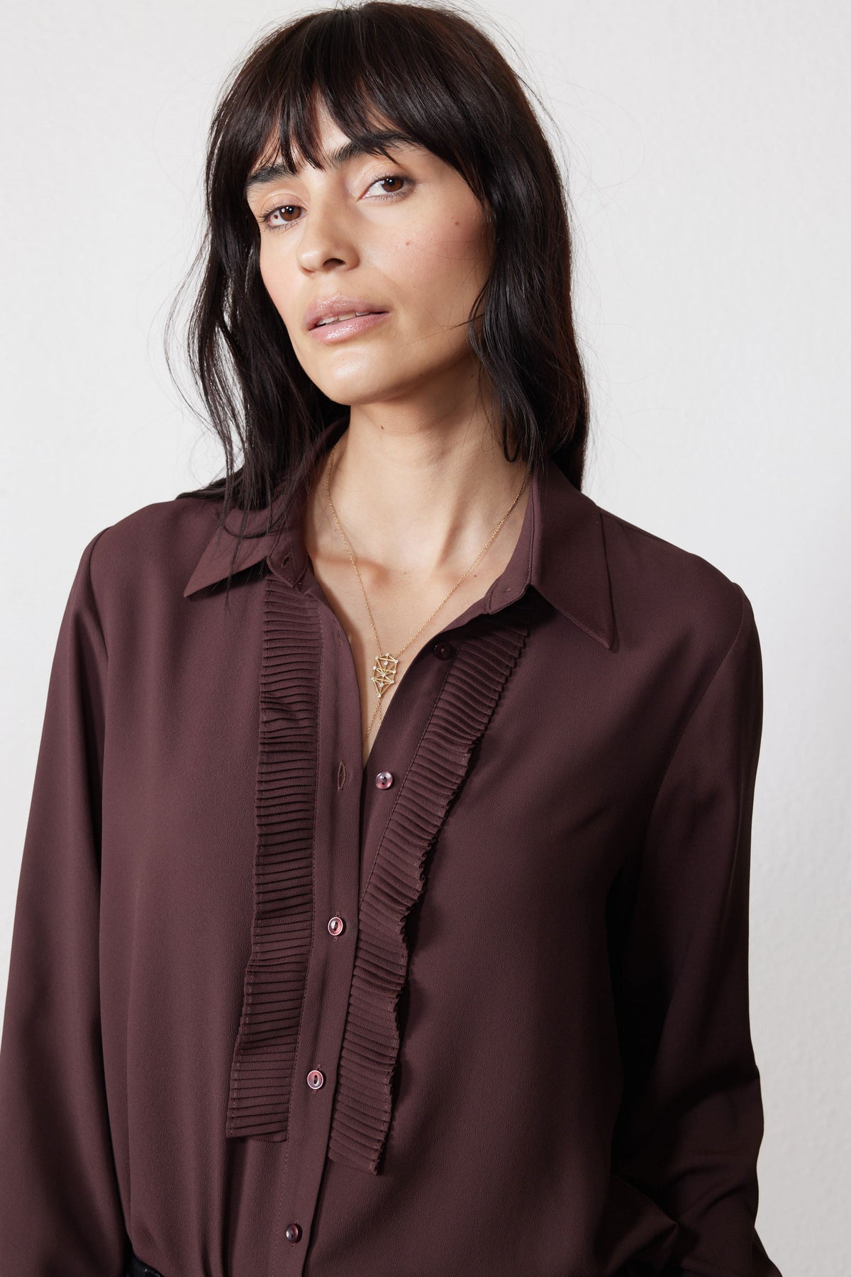 Dark brown blouse close-up with button placket and pleated ruffle front